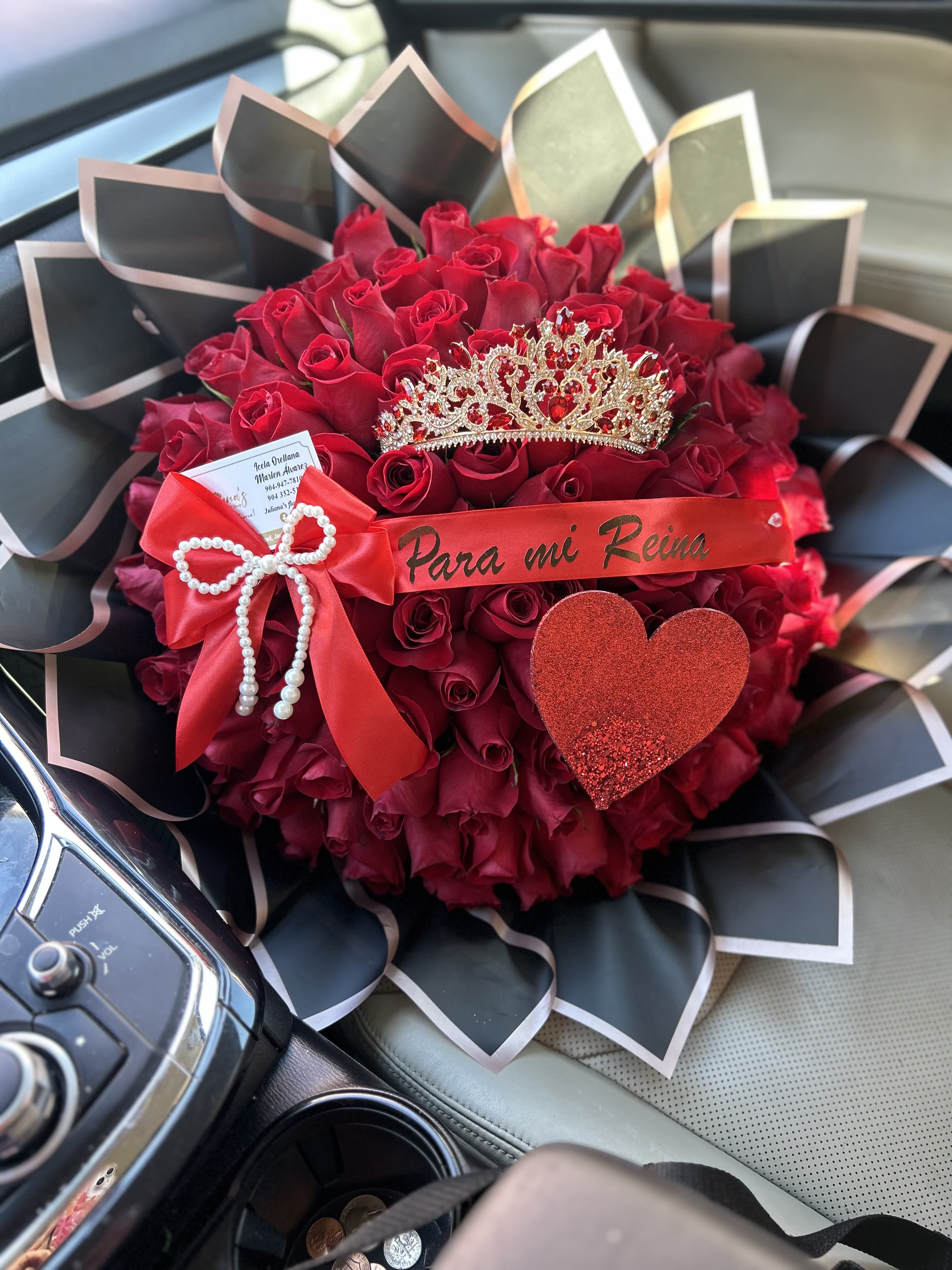 Red rose bouquet with a tiara and ribbon in a car seat