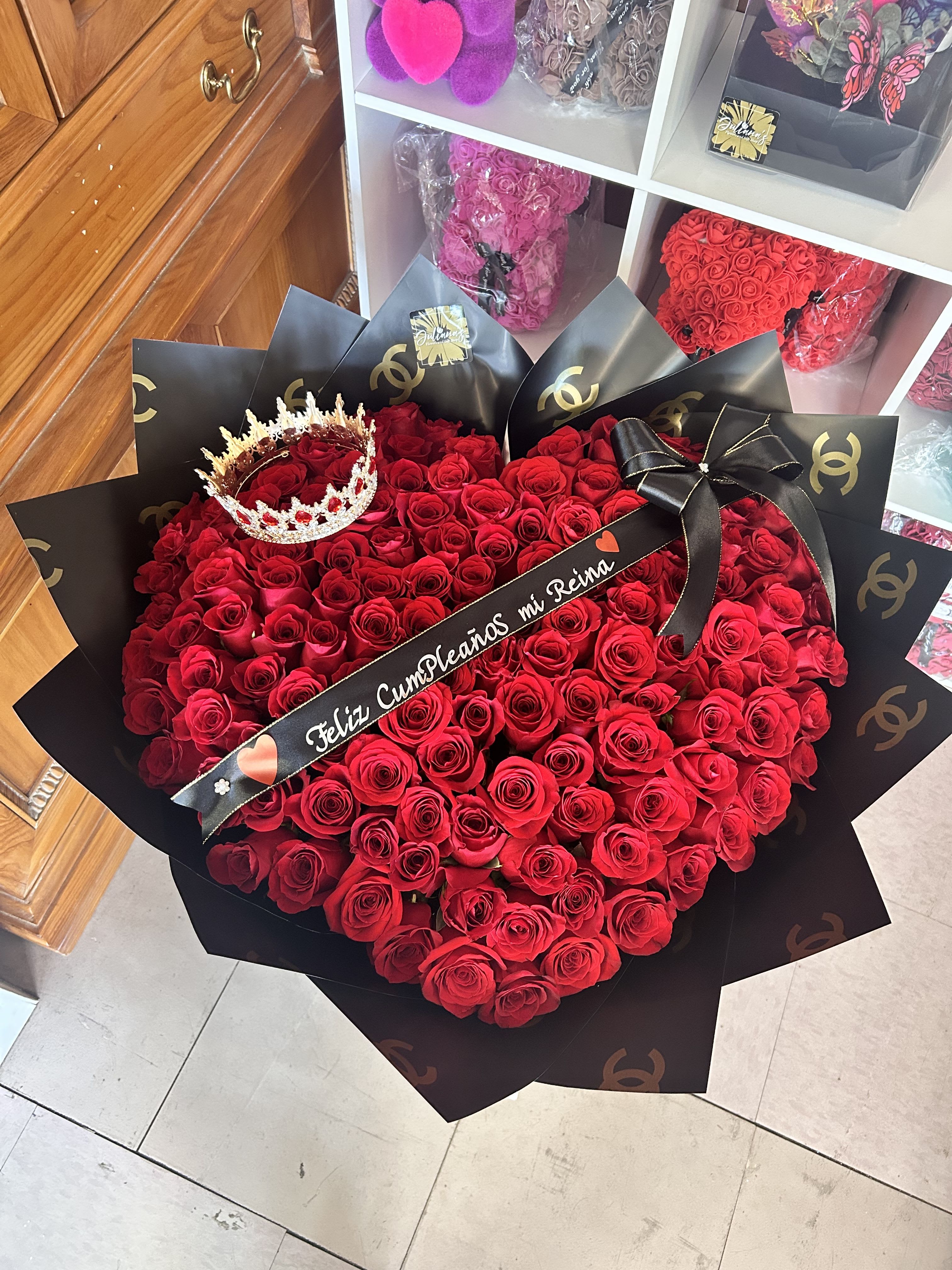 Large bouquet of red roses with a crown and black ribbon