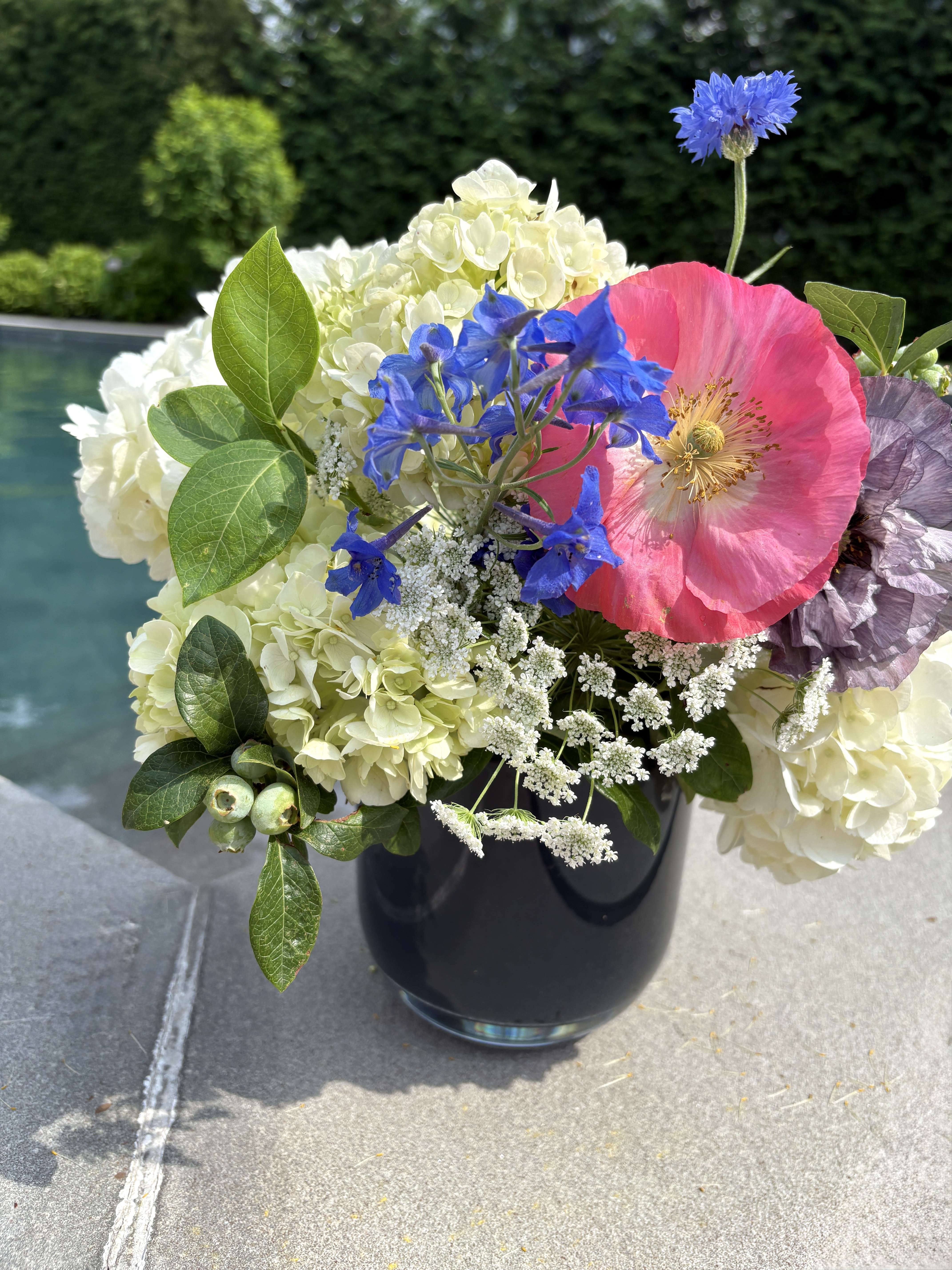 The July  - July is here and so is our new glossy navy blue glass vase filled with white hydrangea, super special red poppies (!!!), cornflower, blueberry foliage and a few other July flowers to compliment this gorgeous gorgeous palette!! 