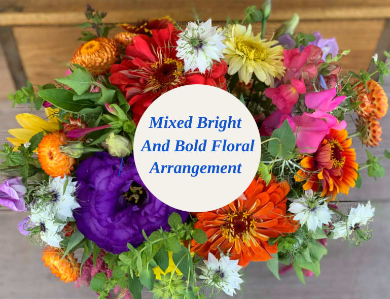 Mixed bright bouquet with colorful flowers and a center label