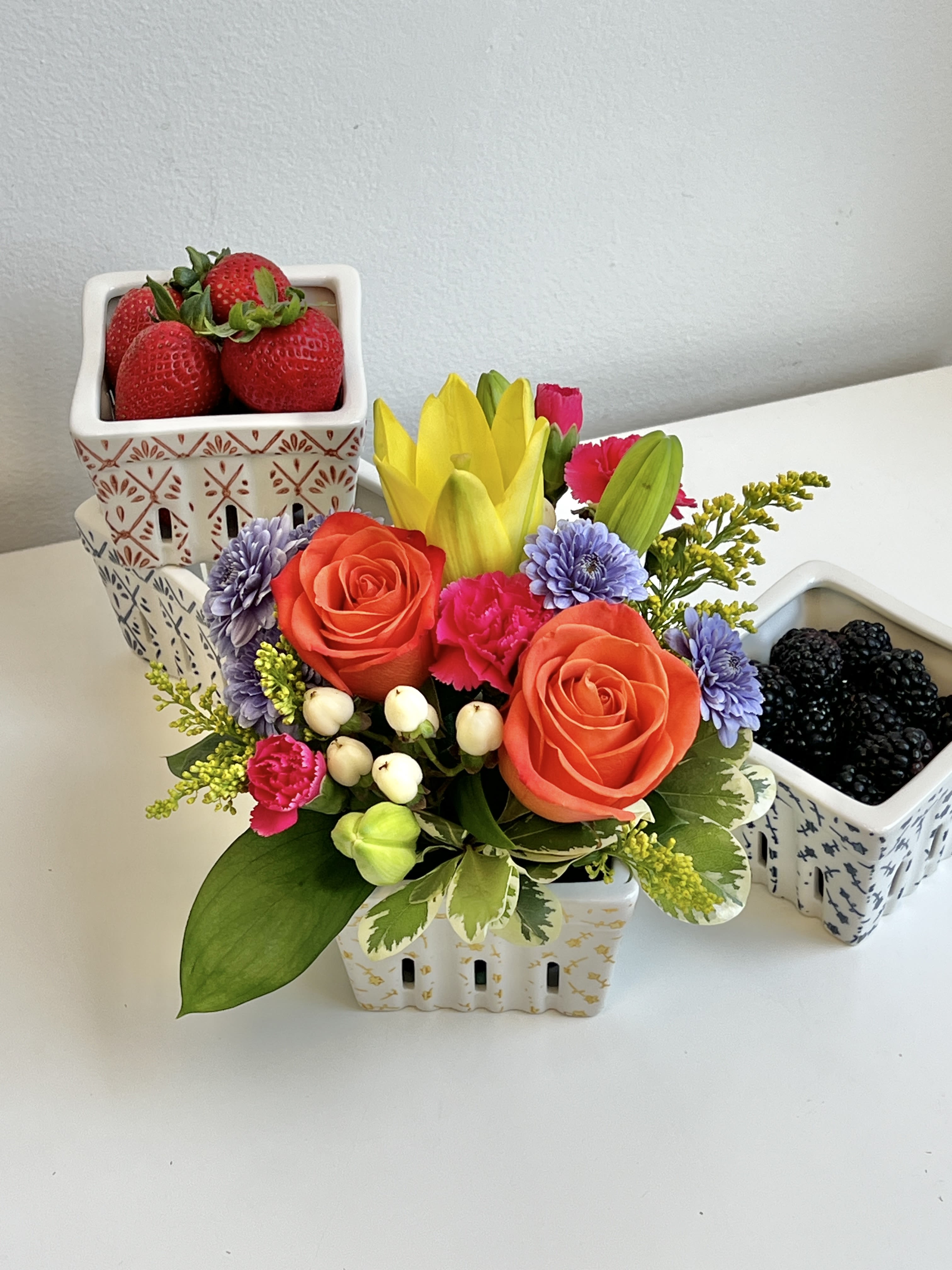 REG-87 - Bright Summer Bouquet With Assorted Colors of Lillies, Roses, Carnations, Mums, Hypericum Berries, Solidego and Foliage in Small Ceramic Assorted Colored Berry Basket.