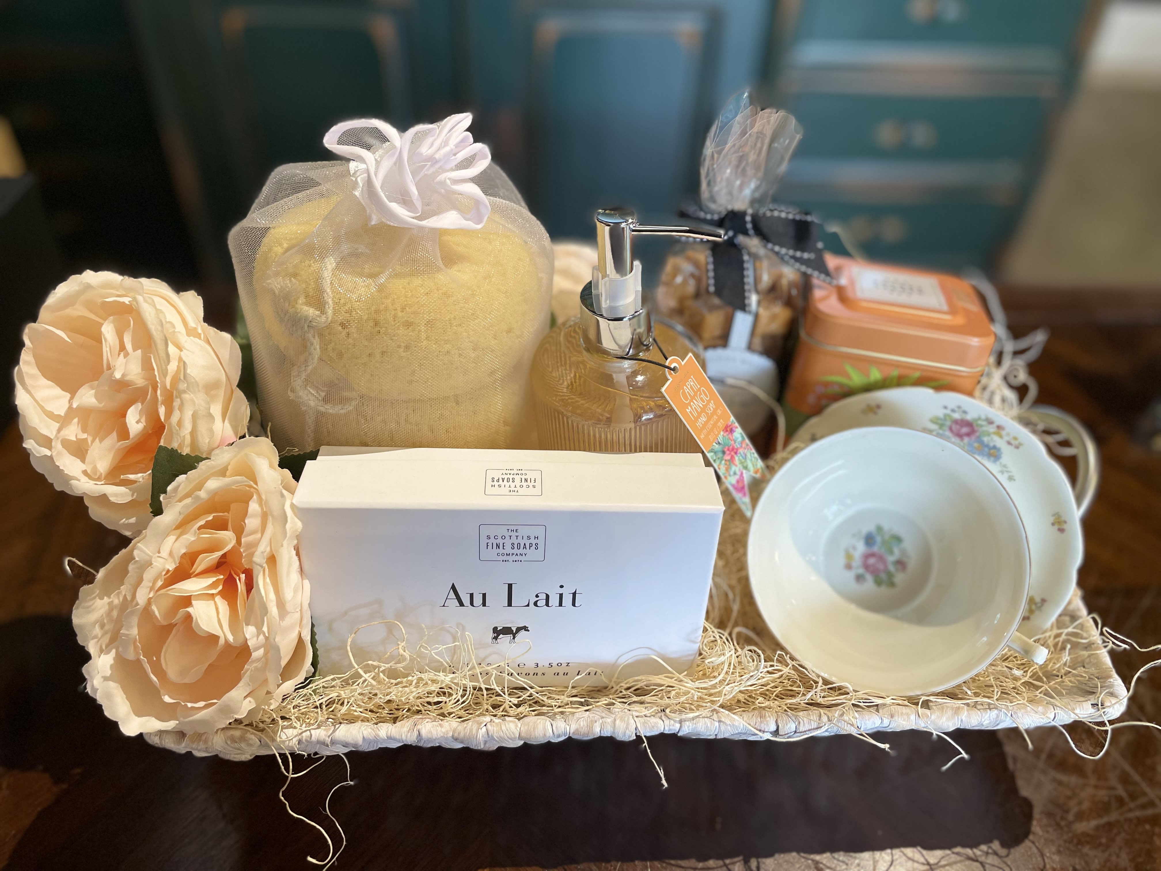 Gift basket with soap, lotion, tea, cups, and peach flowers