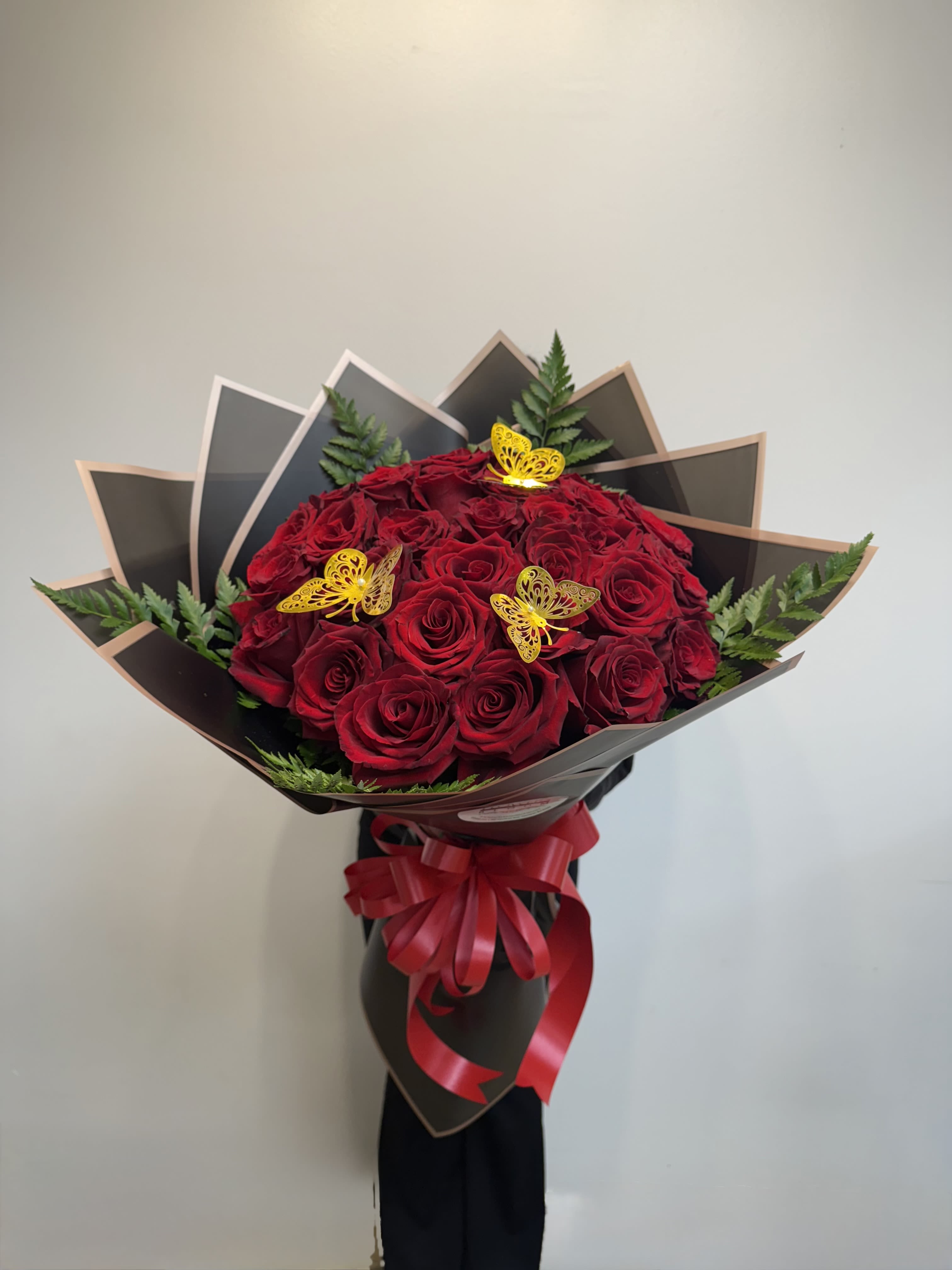 Bouquet of red roses with butterfly picks and a red ribbon