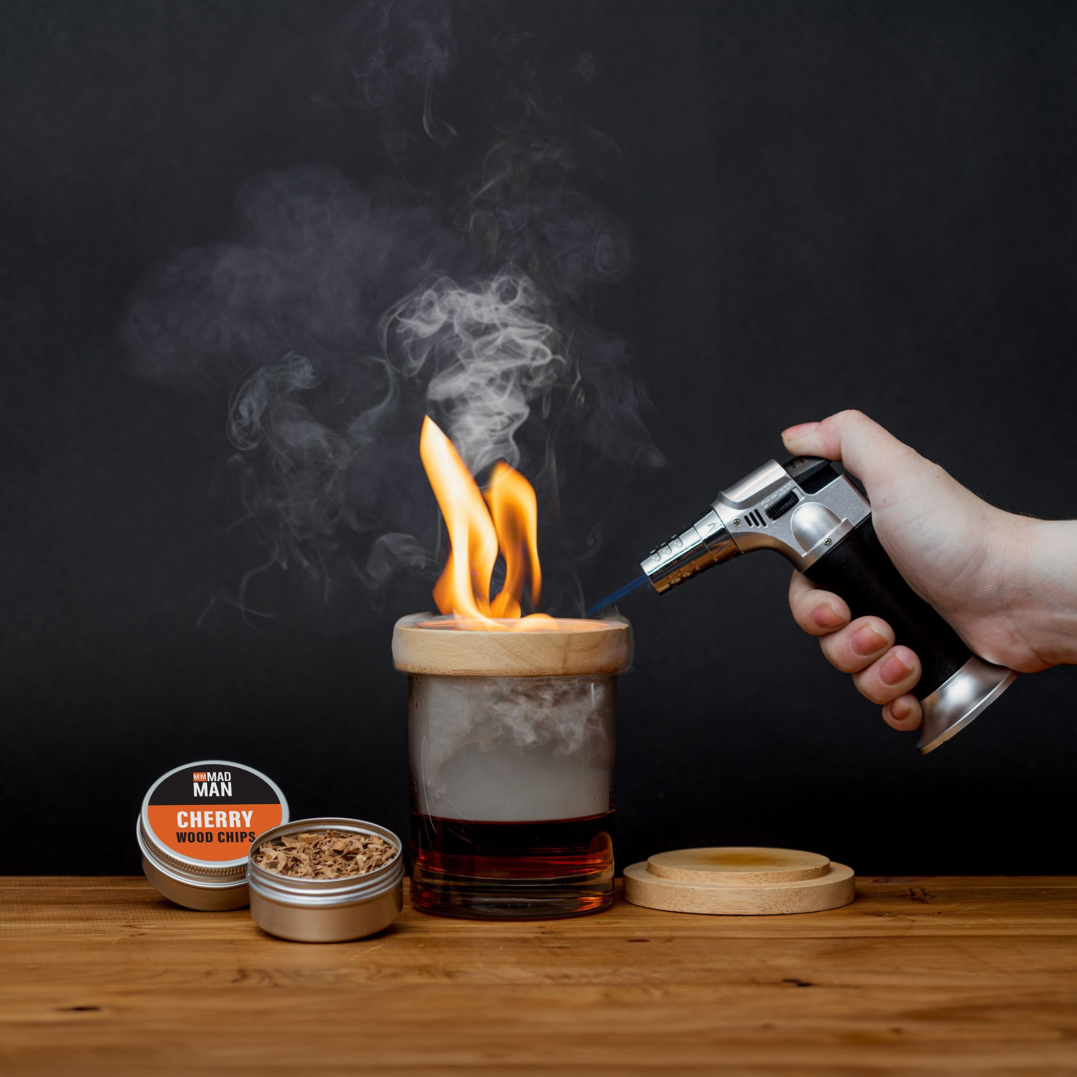 Whiskey Smoker - A striking, unexpected gift for the person who loves cocktails. A whiskey smoker set makes a memorable birthday or Father's Day present that feels handcrafted and thoughtful. Add the rich flavors from the included wood chips to any cocktail.  The bundle includes a portable handheld torch, metal wood chip scoop, and 4 tins of wood chips in cherry, pecan, oak, and apple - all presented in a branded gift box for easy giving.  Give this to the friend who hosts cocktails or the person you're celebrating on a special milestone - it's the kind of gift that says you notice their passions. To enjoy the smoker, follow the included instructions for safe use of the torch, lid, and wood-chip tins so the recipient can add aromatic smoke to cocktails or small dishes.  Ask us about personalizing you gift.