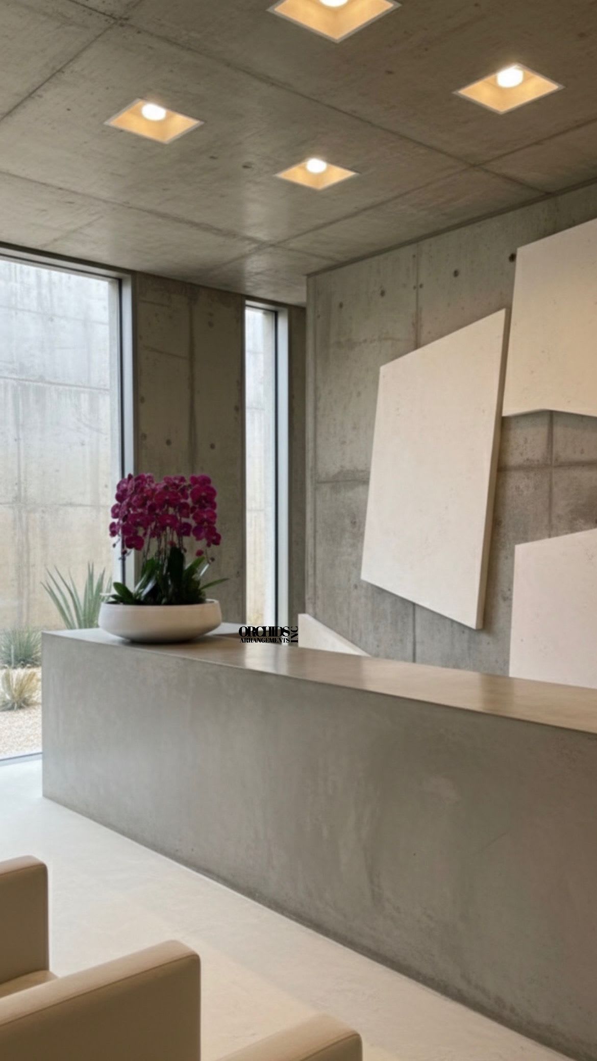 Purple orchid arrangement in a white bowl on a concrete counter