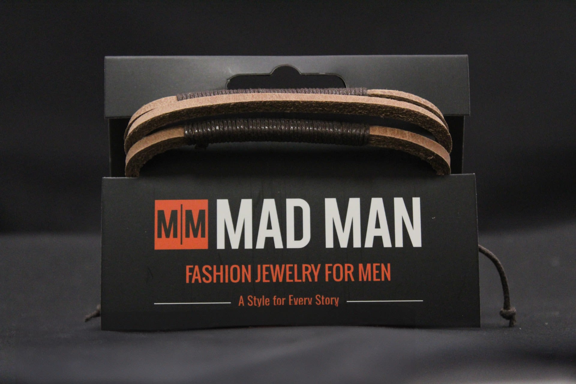 Mad Man Men's Leather Bracelet - Madison - Wrapped in layered brown and black leather with rustic cord accents, this men's leather bracelet reads as a sleek, casual gift for birthdays or "just because" moments. As a fashion accessory rather than a floral item, it's the kind of small, thoughtful present that makes the person you're thinking of feel effortlessly put together - perfect for a brother, boyfriend, dad, or friend who favors understated, masculine style.  The double-wrap band features alternating brown leather and black cord with a wrapped central section and an adjustable tie closure for a comfortable fit.