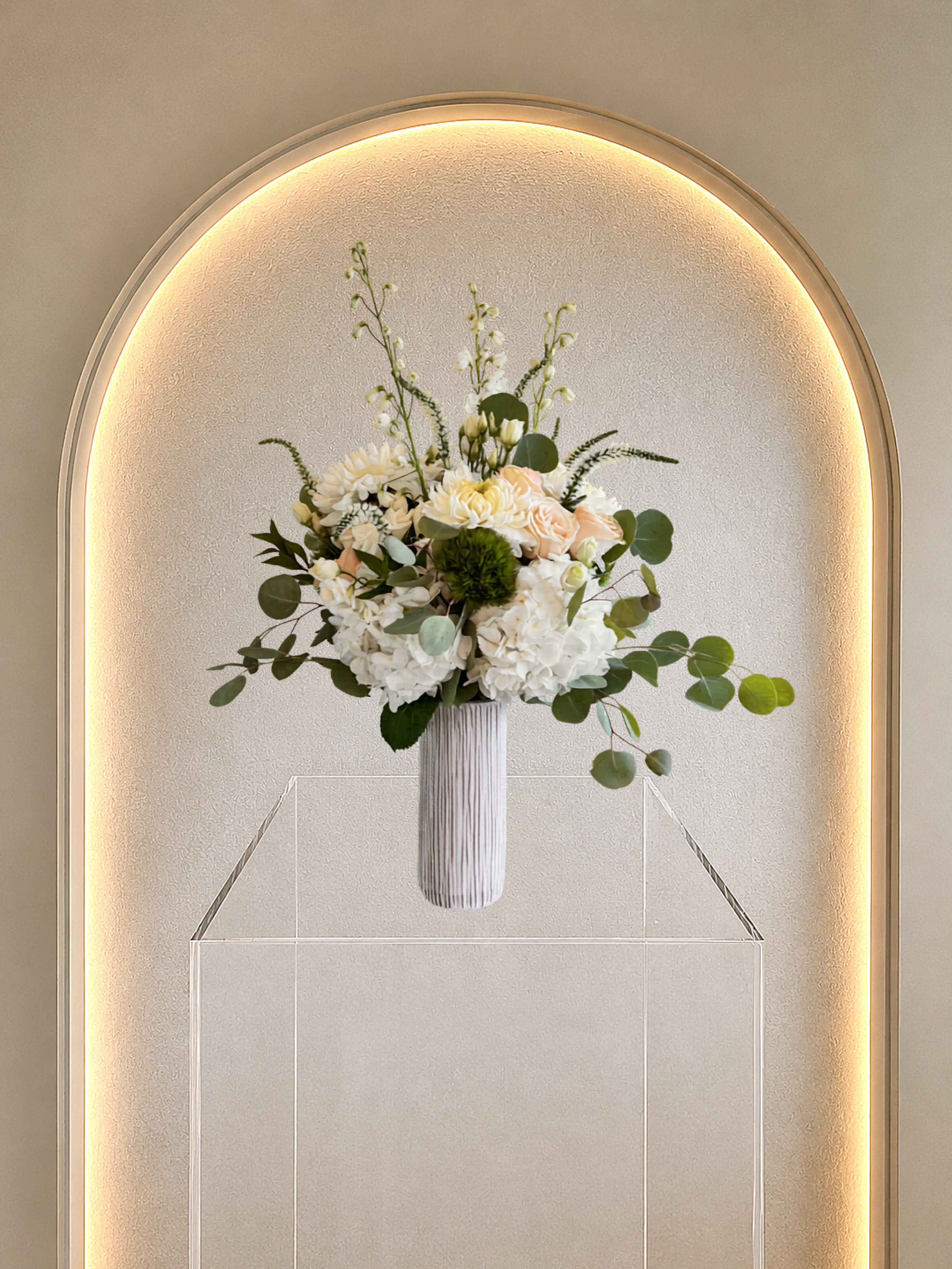 White Elegance - White, blush and peach roses with white accents and eucalyptus in a tall ribbed vase-airy, modern elegance for your home or for any celebration
