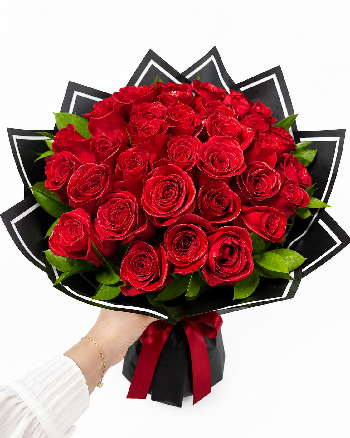 Midnight Romance Rose Bouquet - Make an unforgettable statement with the Midnight Romance Rose Bouquet, a breathtaking arrangement of premium long-stem red roses artfully wrapped in elegant black designer paper and finished with a luxurious satin ribbon. The striking contrast between the rich crimson blooms and the modern black wrapping creates a bold, sophisticated presentation that embodies timeless romance and refined style.  Perfect for anniversaries, Valentine’s Day, birthdays, proposals, or simply expressing deep love and admiration, this bouquet is handcrafted using only the freshest roses and lush greenery to ensure a stunning display from every angle.  Whether you're celebrating a milestone or creating a memorable surprise, the Midnight Romance Rose Bouquet is designed to leave a lasting impression and speak the language of love with unmatched elegance.