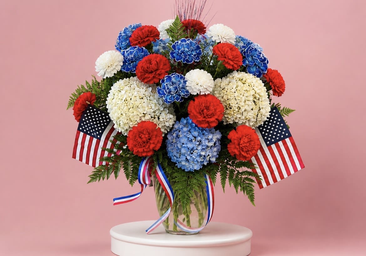 250th 4th of July! - Red, white &amp; blue hydrangeas and carnations in a clear glass vase with ribbon and two American flags-patriotic, festive centerpiece for 4th of July celebrations.