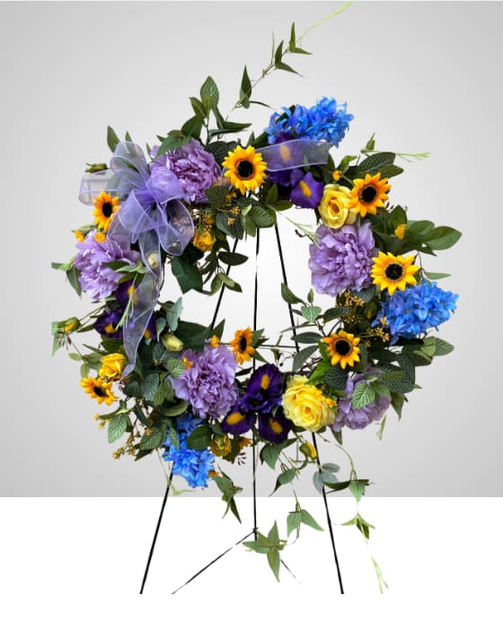 Sunflower Serenity - A silk funeral wreath is a lasting, durable memorial tribute crafted with high-quality artificial blooms and lush greenery. This is a piece that can be displayed at a home on a front door or taken to a memorial space for the loved one who has passed.