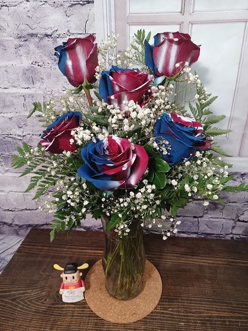 Bouquet of red, white, and blue roses in a glass vase