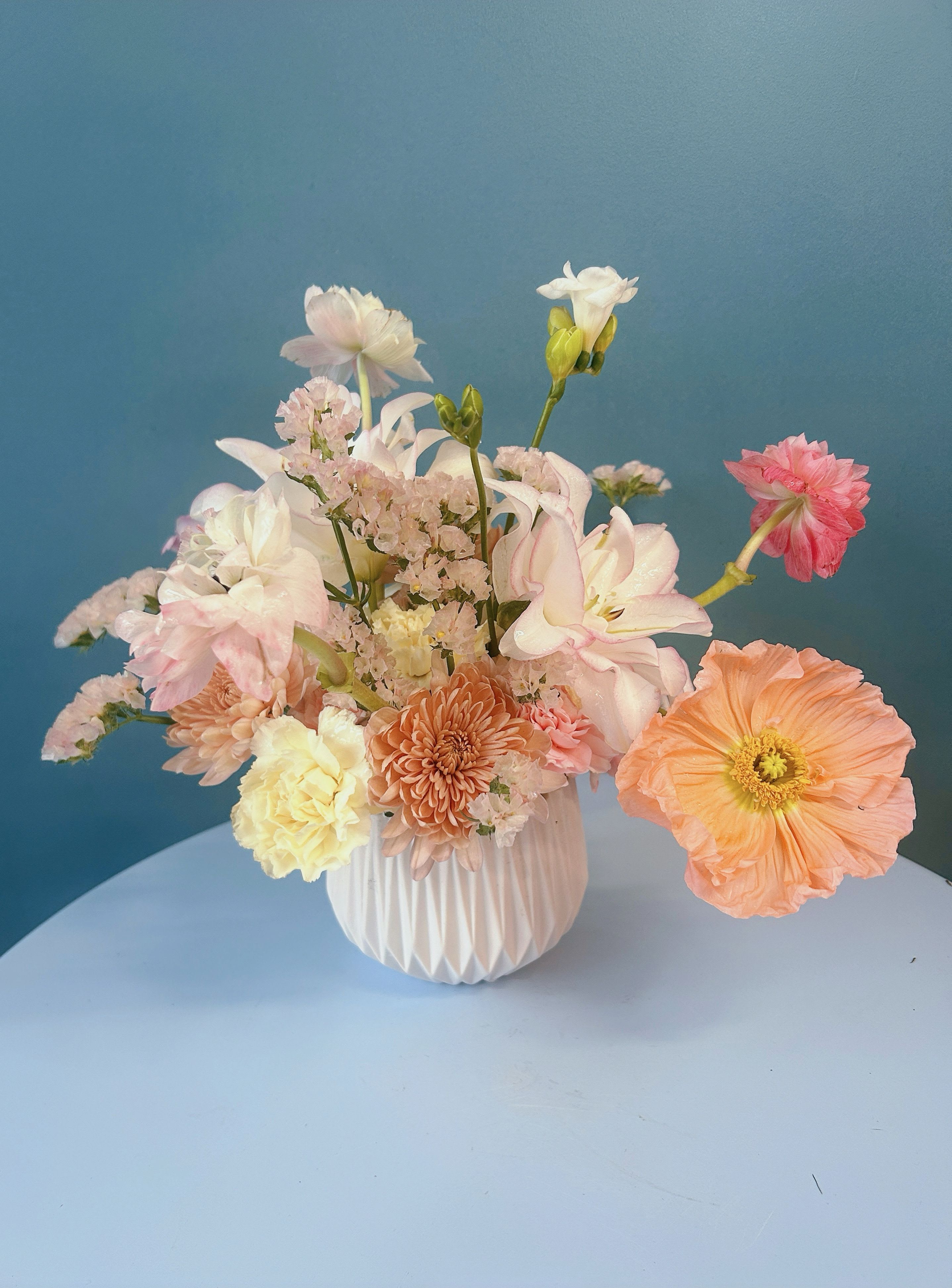Pastel mixed flower arrangement in a white vase