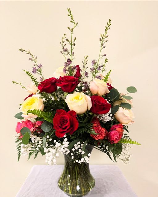 Eternal Romance - A lush cluster of red, cream, and blush roses creates an immediately romantic impression-perfect as an anniversary bouquet, birthday surprise, or a "thinking of you" flower arrangement that makes the person you're sending it to feel truly cherished. The mix of deep reds with soft neutrals and pops of purple gives this floral arrangement a timeless, heartfelt look that reads as both elegant and intimate.  Please note:  There may be substitutions in order to ensure the freshest product for your arrangement.   If you have any special colors you would like included please note in the notes section. 
