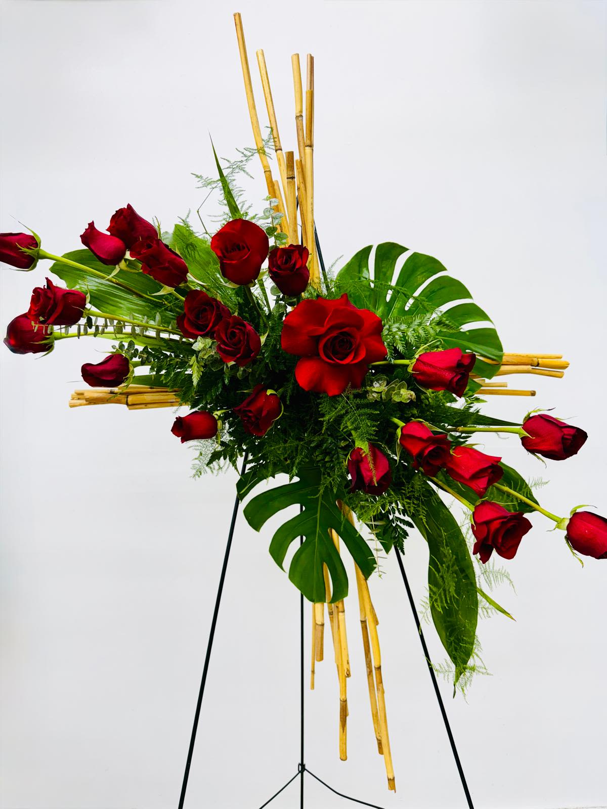 Red roses arranged with tropical leaves on a stand