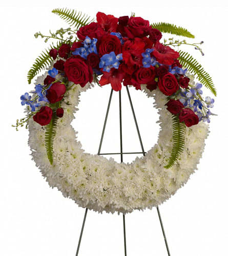 Red and white floral wreath on a black stand