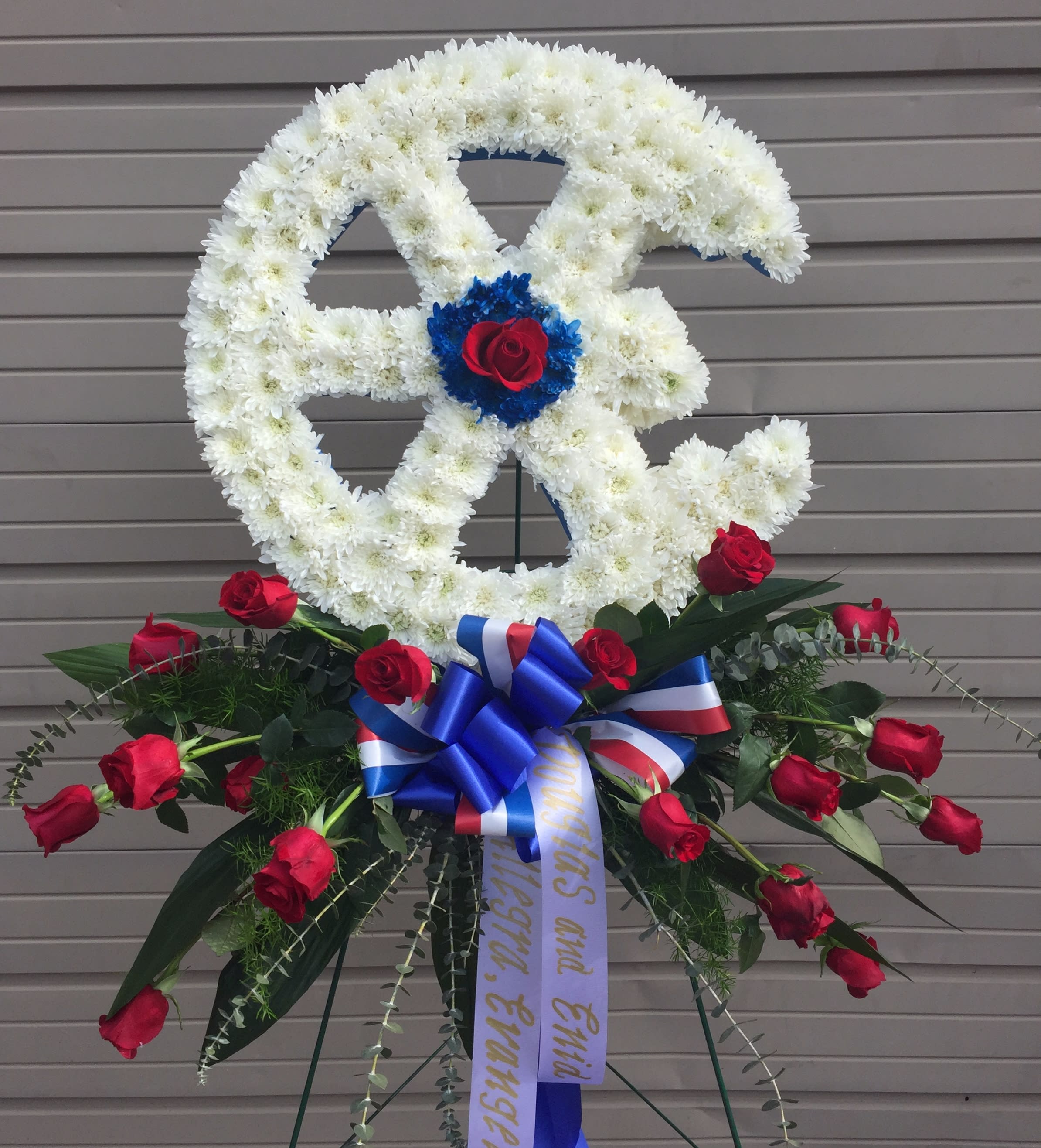 White floral peace sign with red roses and a blue ribbon