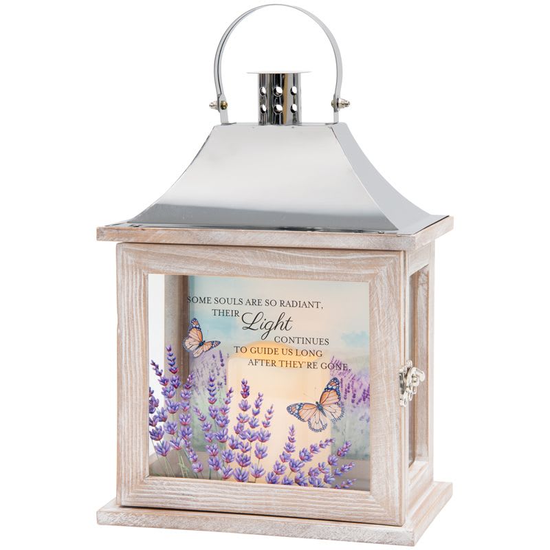 "Their Light" Lantern - Honor the memory of a loved one with this beautiful flameless LED candle lantern. Crafted from quality wood with a stainless steel-finish top, this elegant lantern provides a warm, comforting glow without the worry of an open flame. Suitable for hanging or use as a freestanding item, and it can be incorporated as an accent in floral arrangements.  The lantern features a built-in automatic timer that keeps the candle illuminated for 6 hours on and 18 hours off, making it easy to enjoy every day. It operates on 3 AAA batteries and is designed for indoor use only.  A heartfelt sentiment is displayed on the lantern that reads:  "Some souls are so radiant, their light continues to guide us long after they’re gone."  Features: - Quality wood construction with stainless steel-finish top - Flameless LED candle - Automatic timer: 6 hours on / 18 hours off - Requires 3 AAA batteries - Indoor use only  Dimensions: - Width: 8¾" - Height: 12½" - Depth: 5¼"