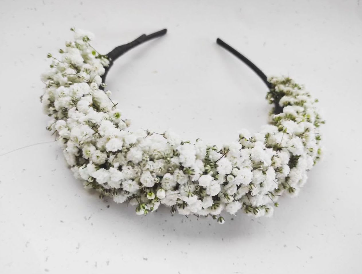White floral headband with clustered tiny blossoms on a black band