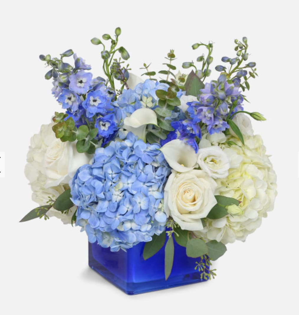 Blue and white floral arrangement in a cobalt square vase