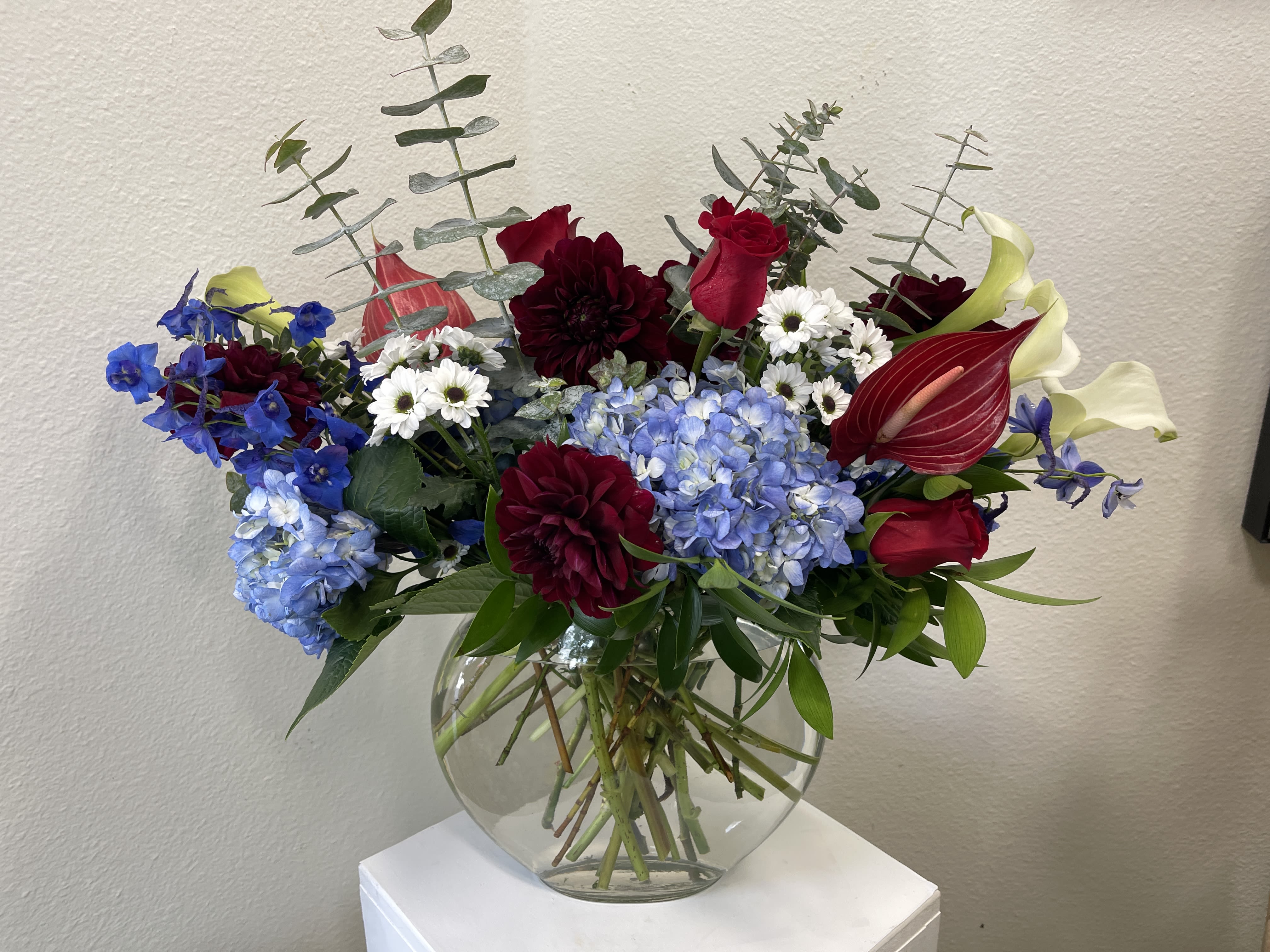 Red, White &amp; Blue - The most premium flowers in patriotic colors. Arranged in a vase that stands out from the rest.