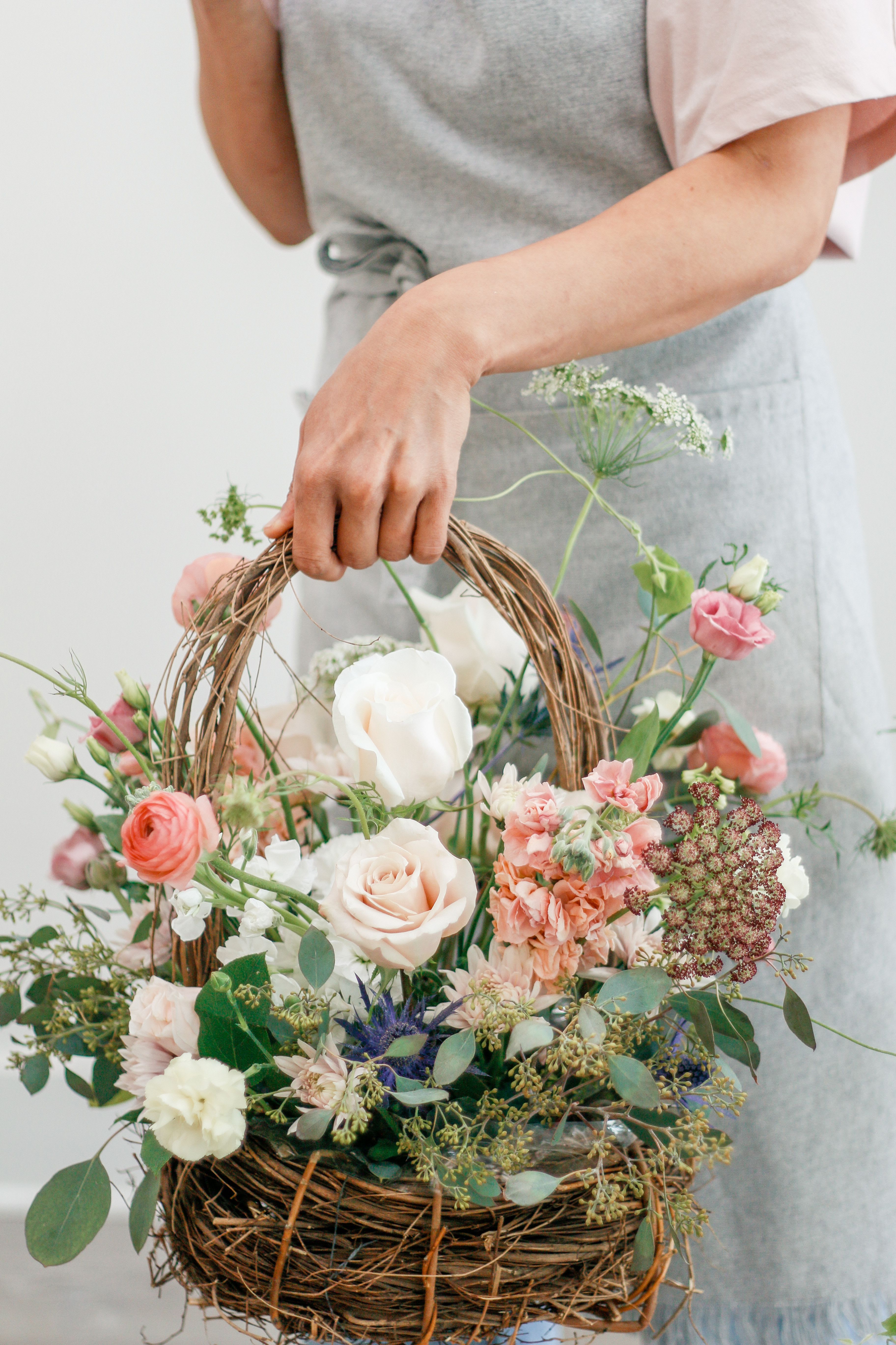 Basket of pastel flowers with roses and carnations