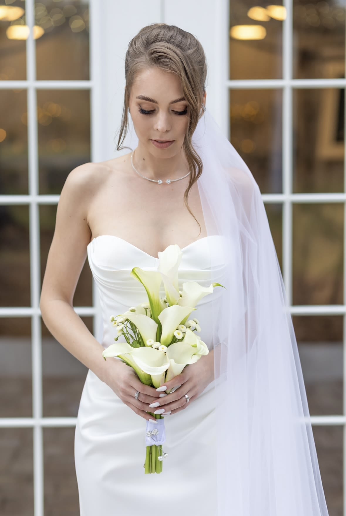 Bride holding a bouquet of white calla lilies