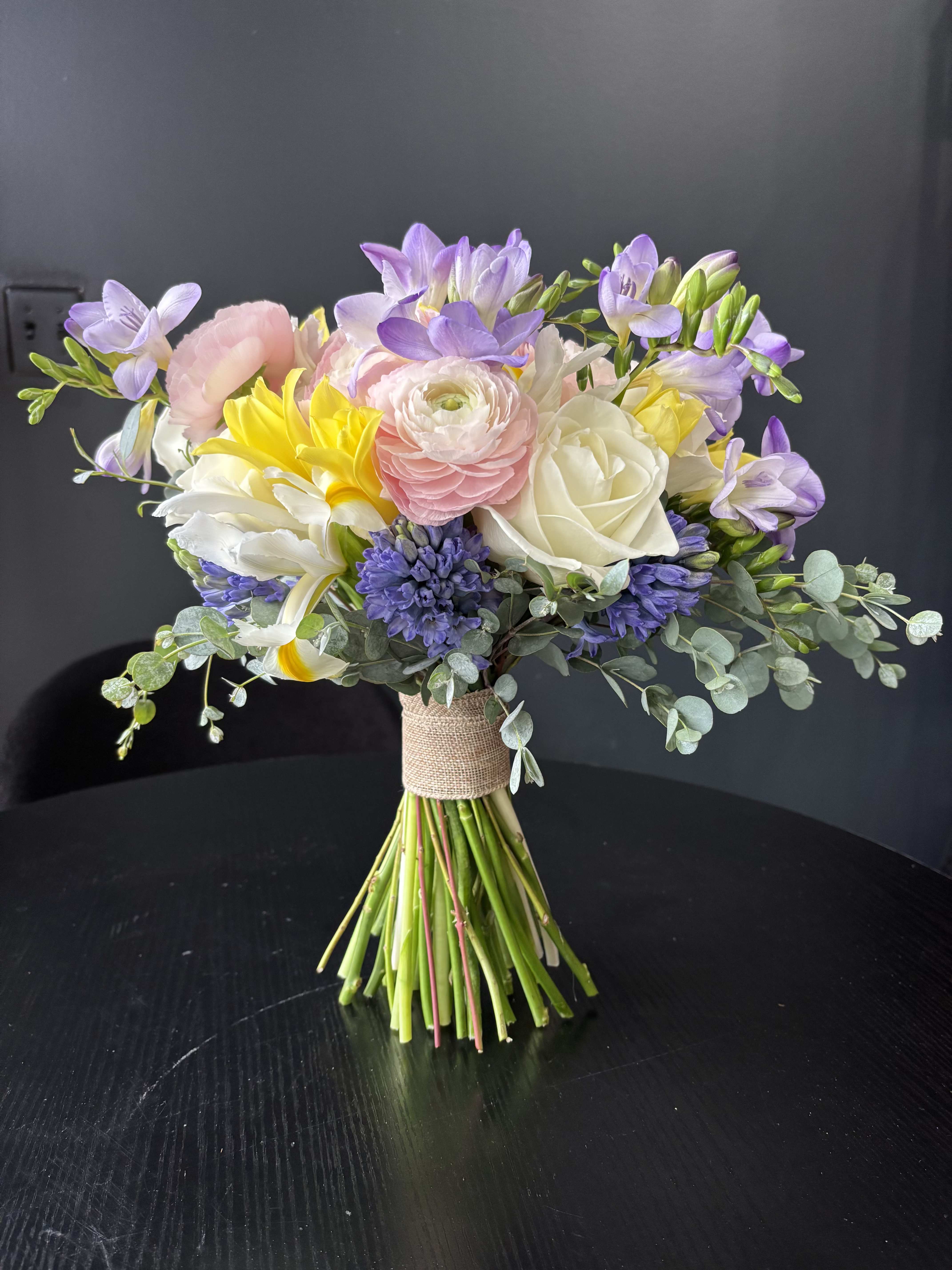 Wedding bouquet with pastel flowers and eucalyptus wrapped in burlap