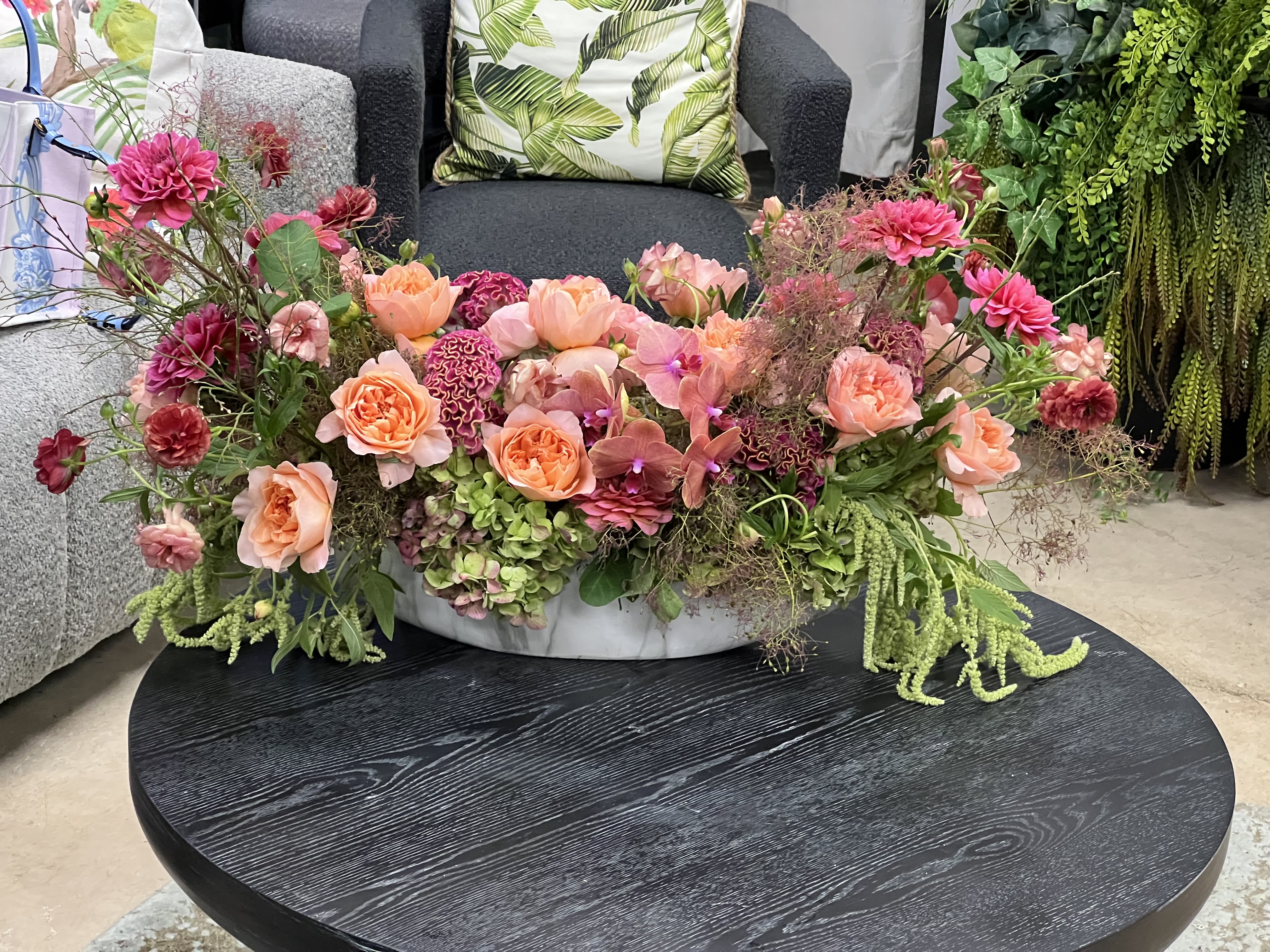Low floral centerpiece with pink and peach blooms in a shallow white bowl