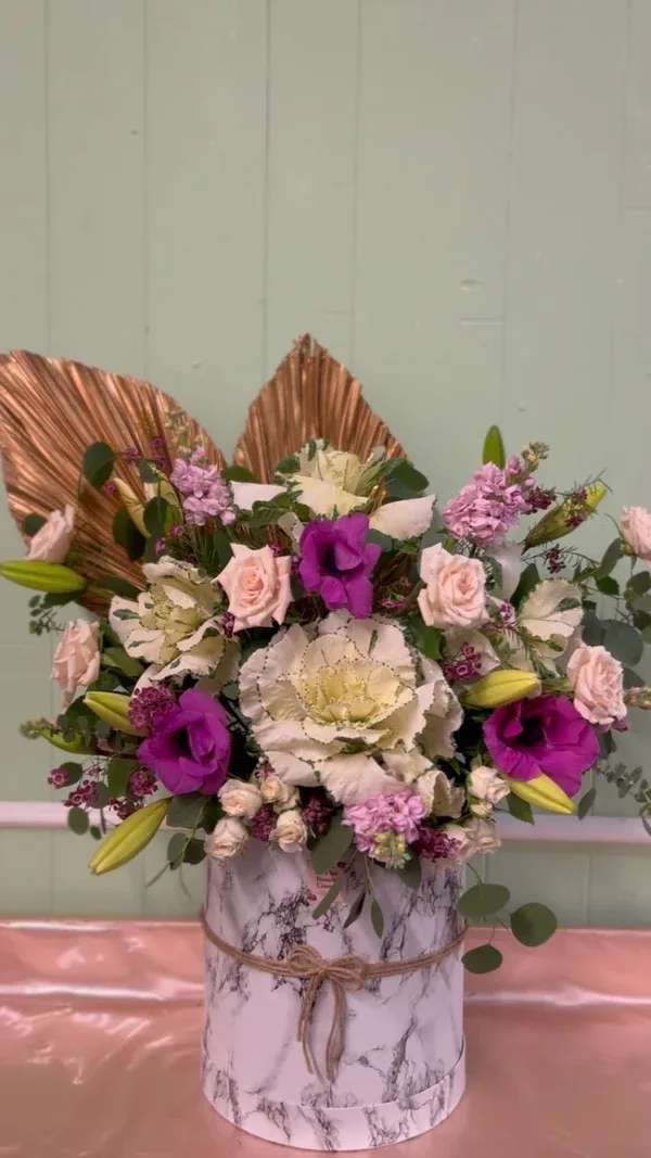 Mixed bouquet with pink and white flowers in a marble-patterned box