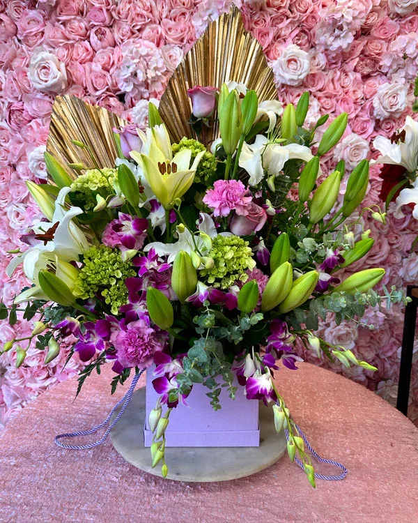 Large bouquet of lilies, orchids, and pink flowers in a box