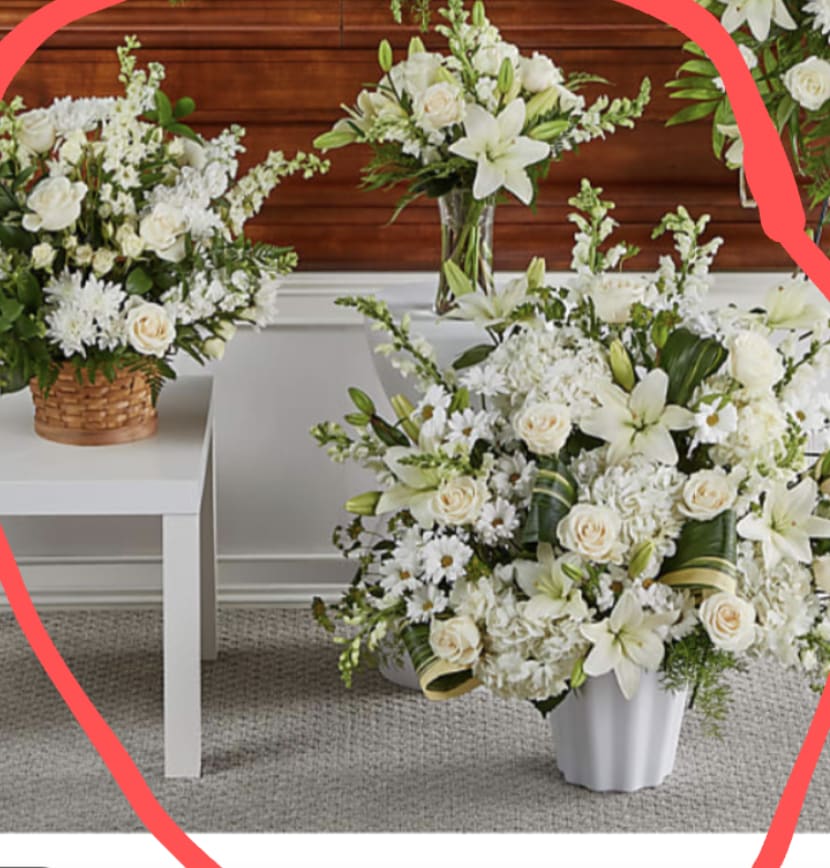 Custom Funeral White 3 Pieces - Soft white blooms arranged across three coordinated pieces create a calm, respectful sympathy arrangement perfect for a funeral or memorial service. This funeral flower arrangement presents white roses, lilies, chrysanthemums and daisy-like blooms with soft green foliage arranged in a woven basket, a clear glass vase, and a white ceramic vase - an understated ensemble that reads as comforting and dignified for those you're honoring.  Each piece pairs creamy roses and fragrant lilies with textured chrysanthemums and smaller daisy-type flowers for gentle contrast and long-lasting presence. The palette is all-white with subtle green accents, and the mix of containers (woven basket, clear glass vase, white ceramic vase) lets you place the pieces together at a service or spread them through a home. Sizes are intended to work as a grouped tribute or as simple home displays, offering a fresh, airy look that won't overpower a space.  Designed to convey sympathy and quiet support, this set gives the person you're thinking of a measured, elegant expression of care during a difficult time. These flowers are selected for lasting vase life; keep them in cool water, recut stems and refresh water daily for best results. Orders can be arranged to deliver directly to a funeral home or family residence.
