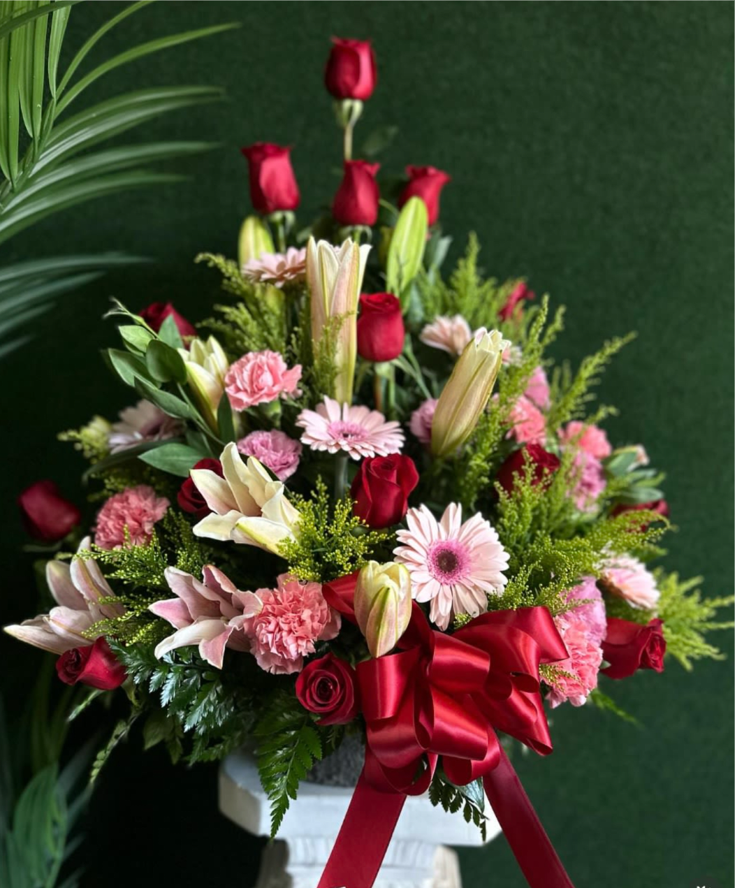 Gerber Daisy And Rose Pyramid Arrangement - 15 red roses with pink gerber daisies, pink carnations, lilies, all nestled in lush greenery and solidago. 