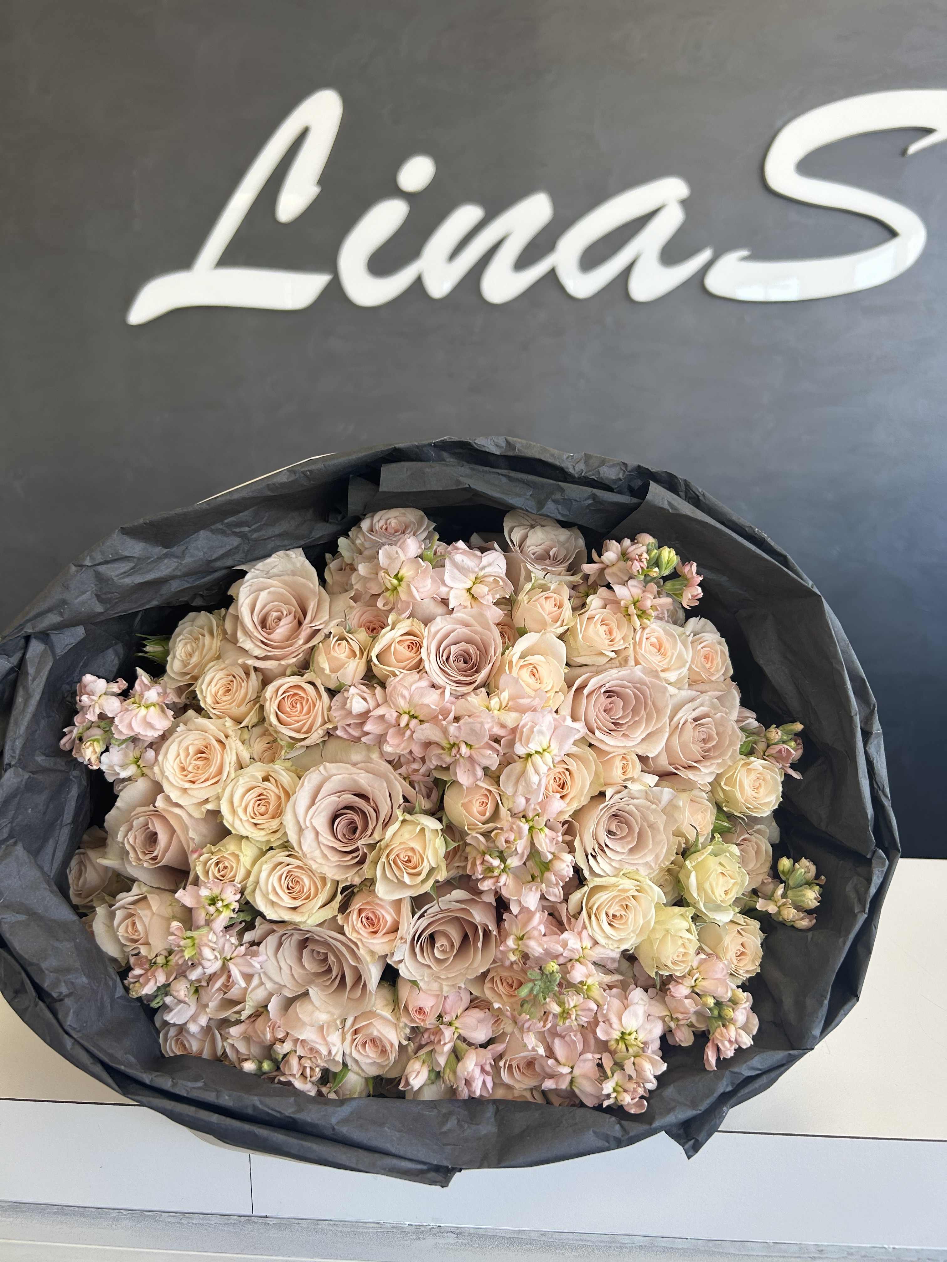 Large bouquet of pale pink and cream roses with small pink filler flowers