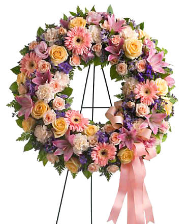 Floral wreath with pink and yellow flowers on a stand
