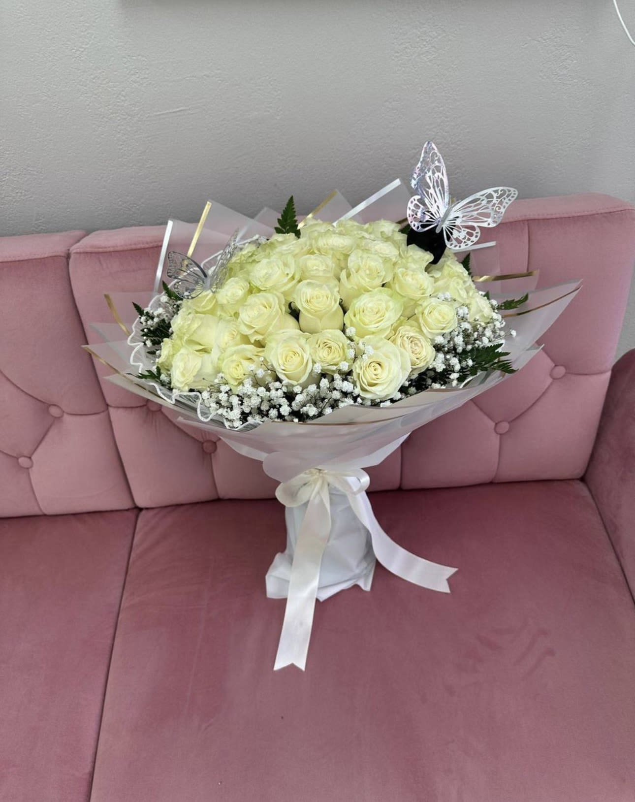Bouquet of pale yellow roses with white baby's breath and butterfly picks