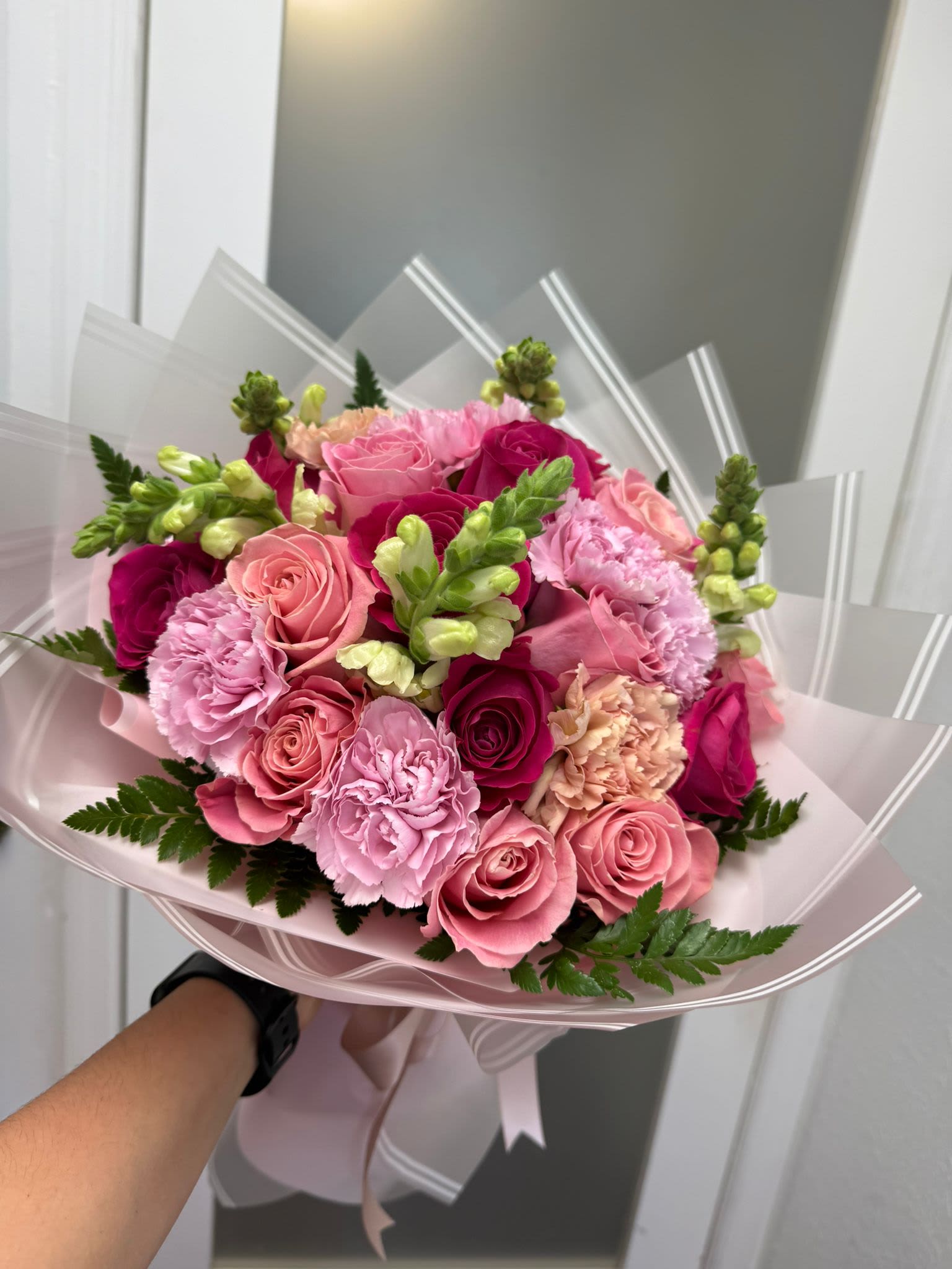 Pink rose and carnation bouquet wrapped in pale pink paper