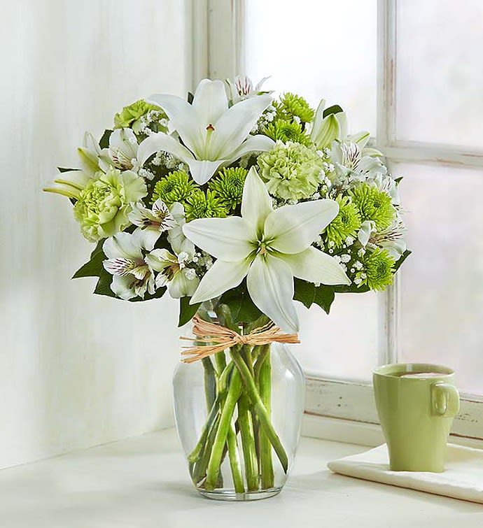 White lilies and green chrysanthemums in a glass vase