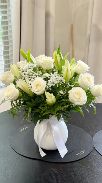Classic All White Arrangement - Express your heartfelt condolences with our elegant Graceful White Roses &amp; Lilies Vase. This timeless arrangement features premium white roses, fresh white lilies, delicate baby's breath, and lush greenery beautifully designed in a keepsake white vase. A graceful expression of sympathy, remembrance, comfort, and peace, thoughtfully handcrafted by Lone Star Gifts. Available for same-day flower delivery in Midland, Odessa, and surrounding Texas communities.