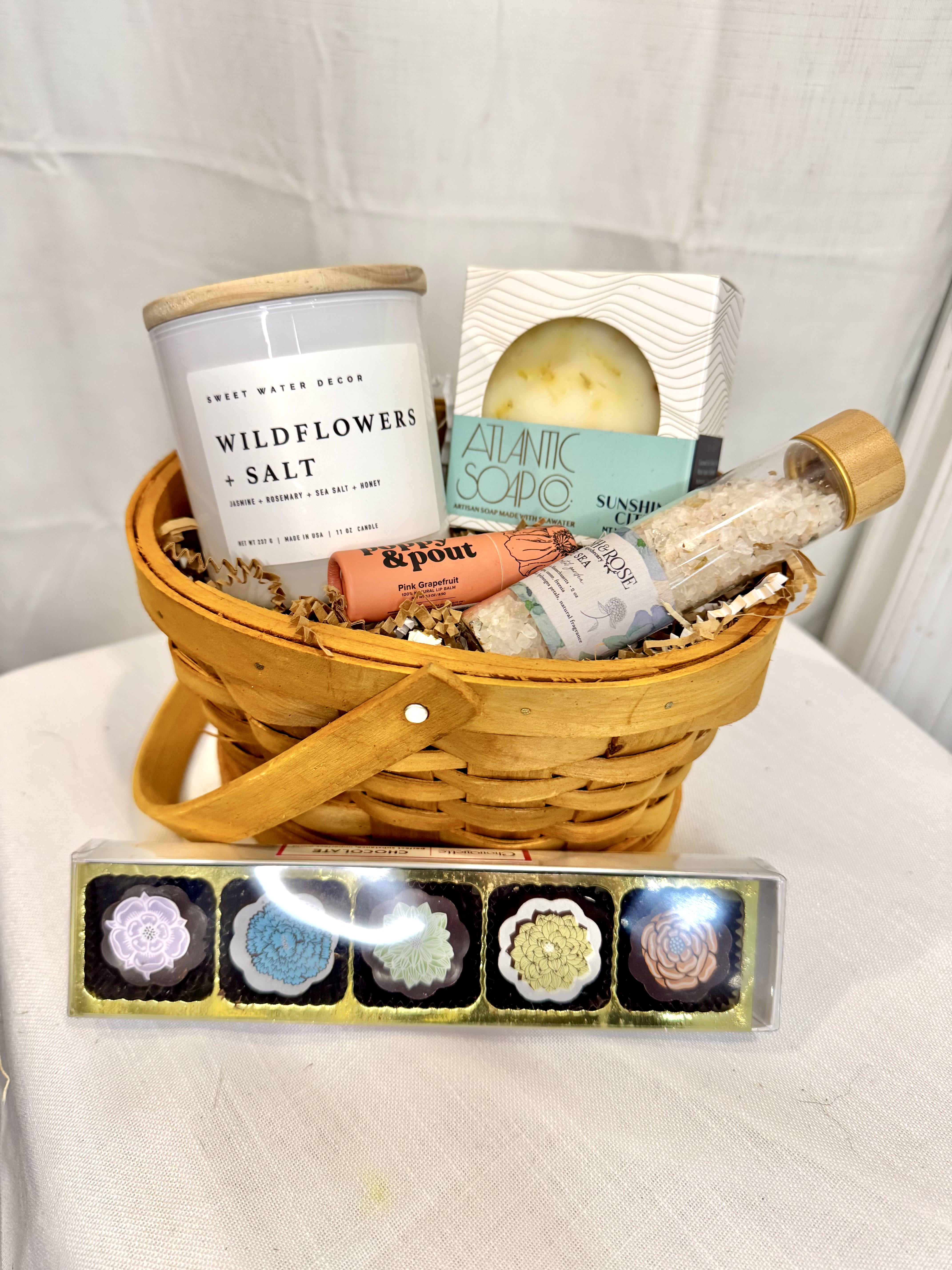 Gift basket with candles, soap, bath salts, and lip balm