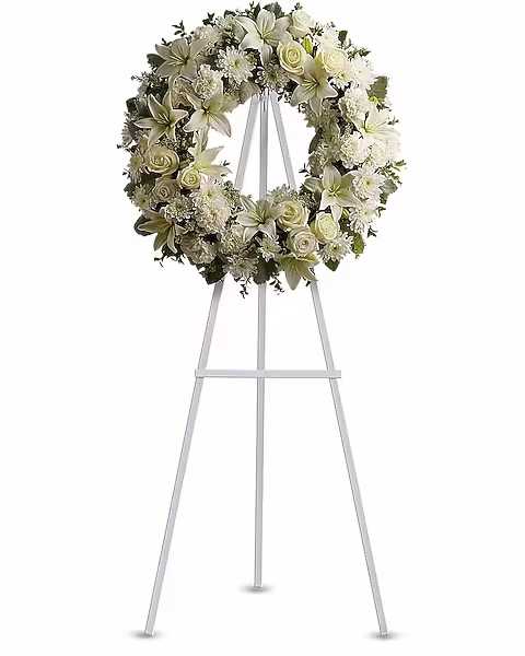 Serenity Wreath - A ring of fragrant, bright white blossoms will create a serene display at any funeral or wake. This classic wreath is delivered on an easel, and is a thoughtful expression of sympathy and admiration. A standing wreath created from fresh white flowers such as roses, Asiatic lilies, carnations and cushion spray chrysanthemums - accented with greenery - is delivered on an easel.  