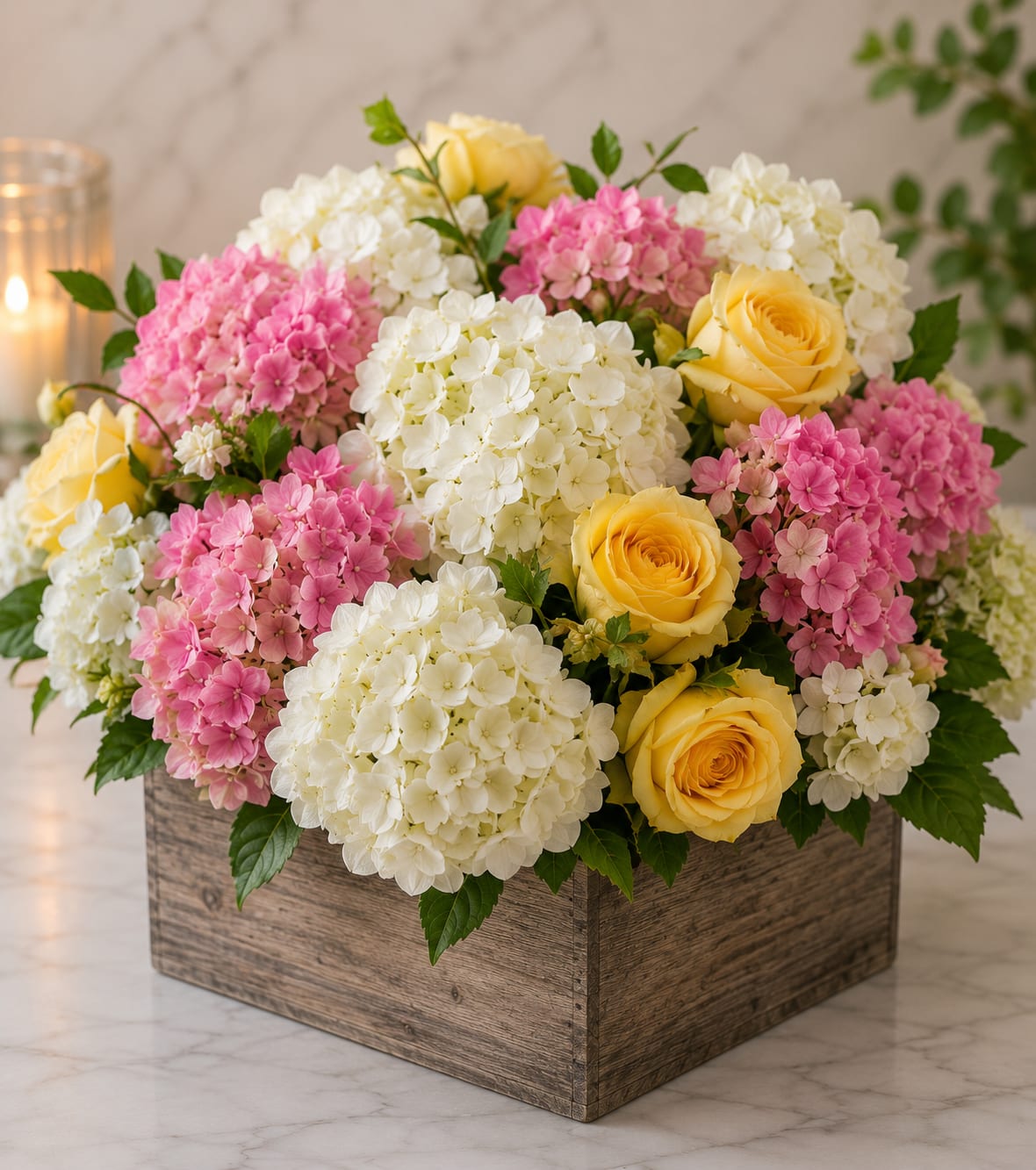  Garden of Hope - Rounded clusters of pink and white hydrangeas mingle with sunny yellow roses to create a soft, garden-style bouquet perfect for a birthday, spring celebration, or a heartfelt thank-you. This flower arrangement delivers a cheerful, gentle impression-the kind that makes the person you're thinking of feel noticed and comforted without being overdone.  Packed closely into a rustic wooden box, the composition reads full and abundant, with the fluffy texture of hydrangea balancing the classic shape of roses. Colors are pastel pink, creamy white, and warm yellow; dimensions follow the compact, tabletop-friendly profile of a boxed arrangement and it arrives ready to display. Ideal for everyday gifting or brightening someone's home, this piece shows care in both presentation and sentiment.