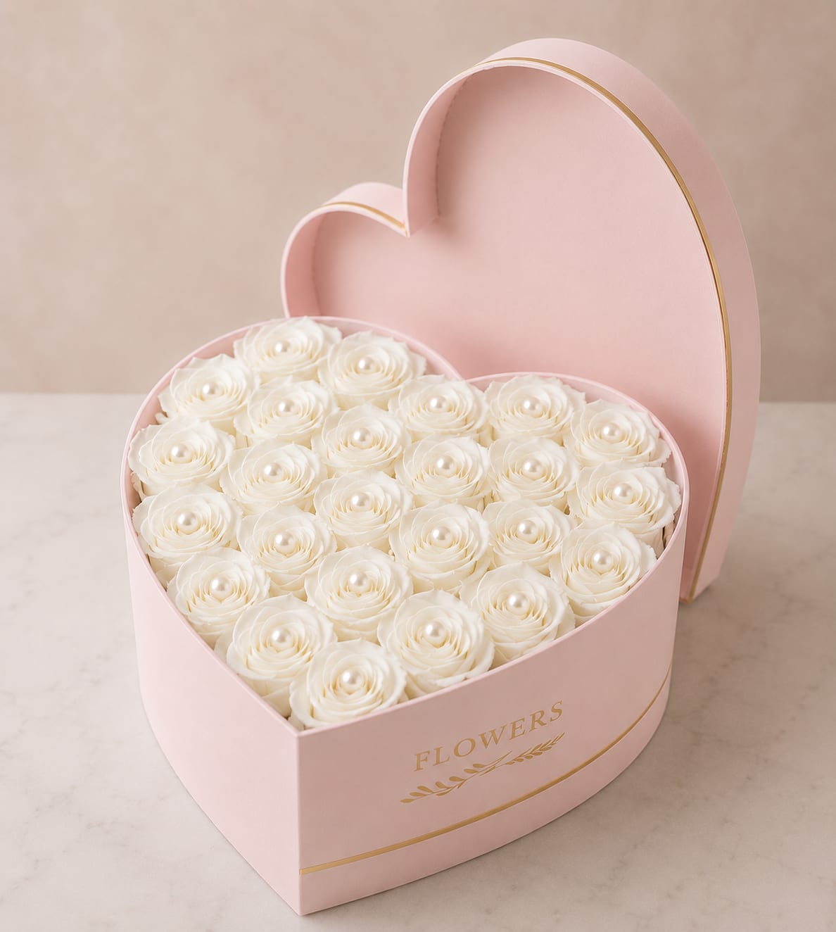 Eternal Purity - Tightly packed garden-white roses nestle inside a pale pink heart-shaped box edged in gold, making this boxed rose arrangement an unmistakable romantic gift for anniversaries, Valentine's Day, or any moment you want someone to feel truly cherished. The compact heart silhouette reads as both playful and refined, so the person you're thinking of will open something that looks like a keepsake as much as a bouquet.  The design uses only white roses for a soft, monochrome effect that emphasizes petal texture and graceful form against the gentle blush of the box. The blooms are arranged edge to edge for a full, polished presentation; the pale pink container with gold trim doubles as a decorative gift box that can be reused. Because the box is the focal vessel, this is offered as a boxed arrangement rather than a vase display-perfect for presenting as a surprise or placing on a bedside table or desk for lasting visual impact.