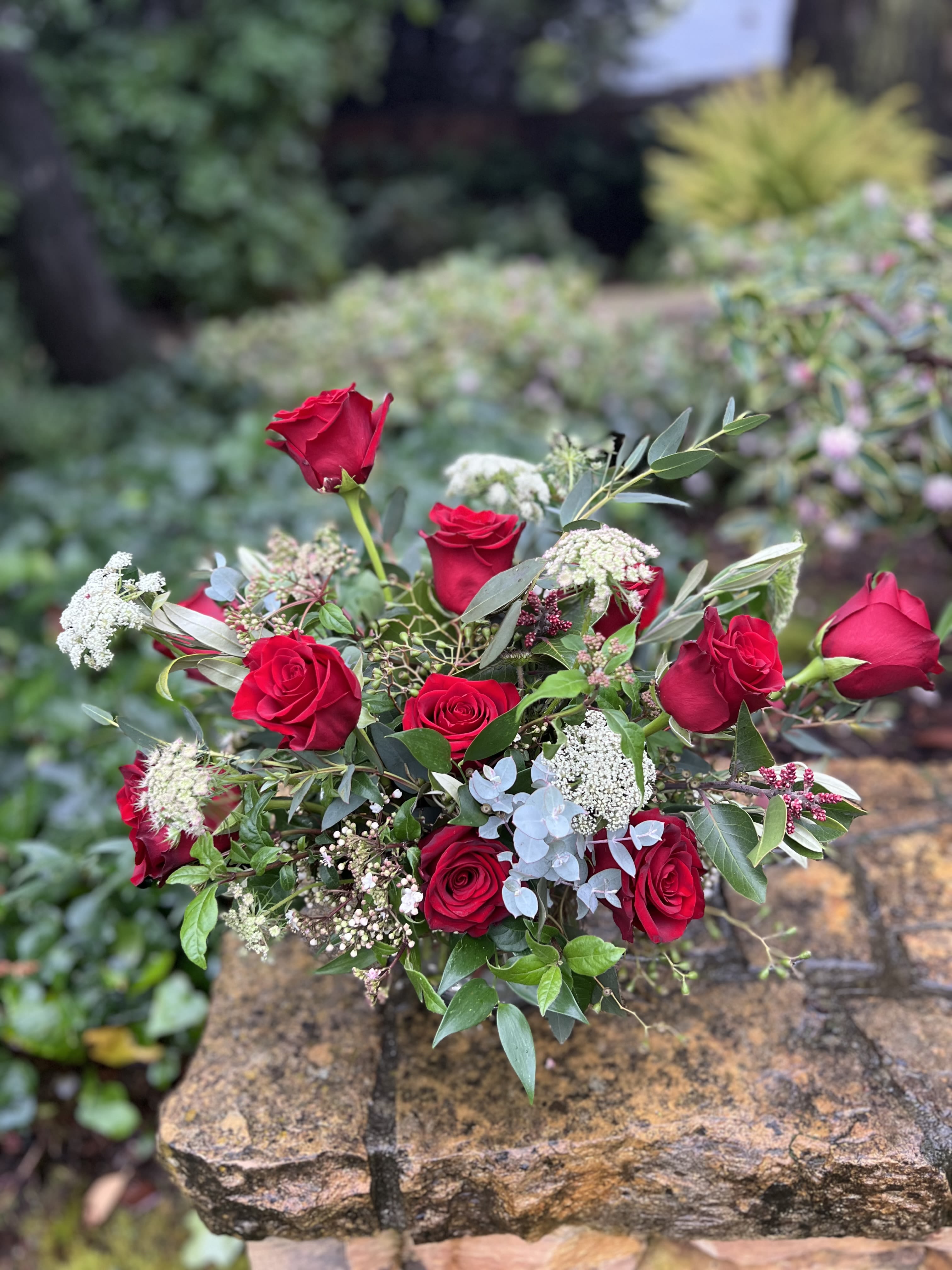 Red Roses from the Garden  - Our organic take on the timeless dozen red rose design. Low enough to fit on the dining table for a romantic dinner but still created to make a grand impression. Perfect for any rose lover! Available in 12, 18, or 24 stems. 
