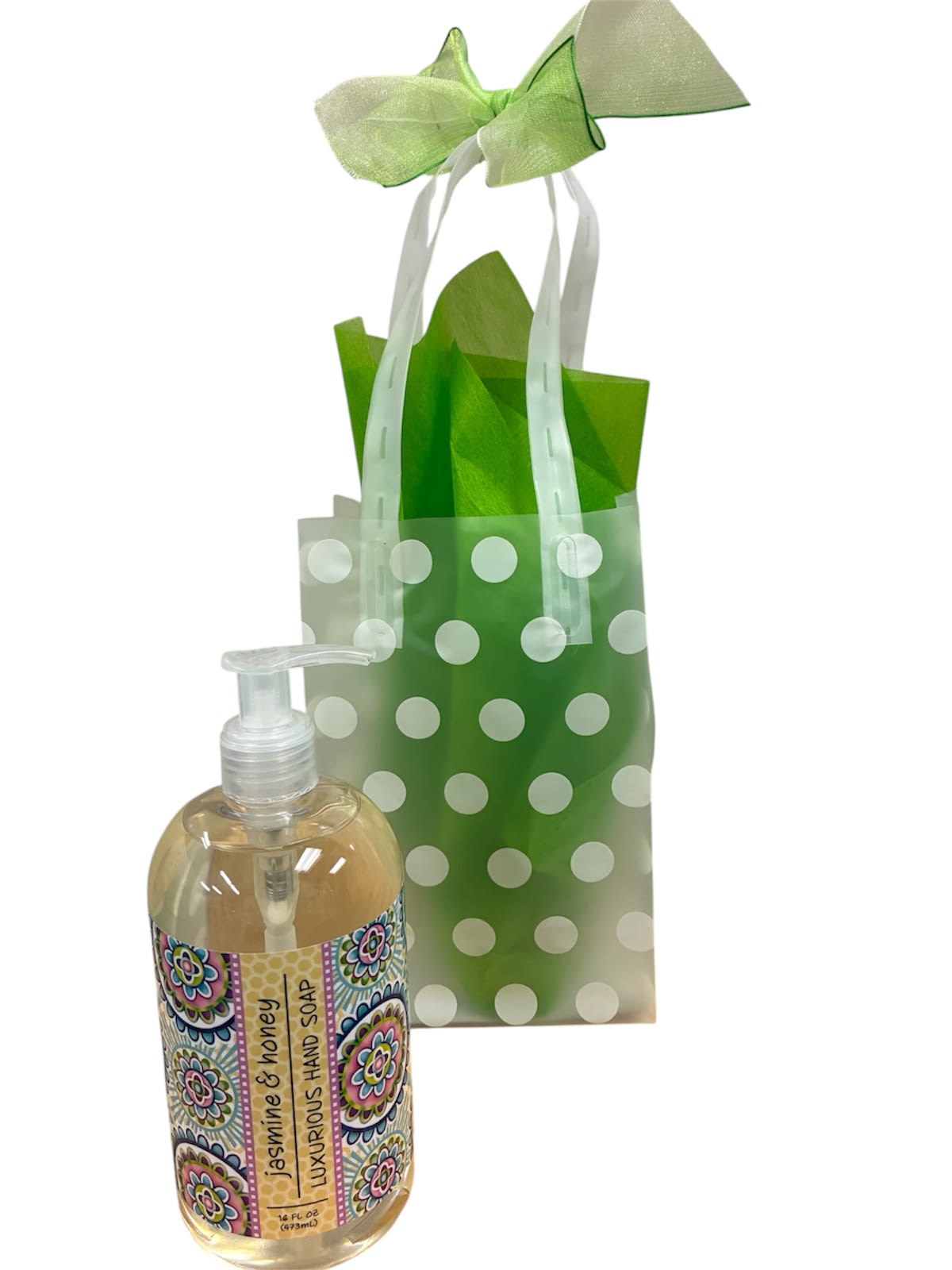 Jasmine Soap - A cheerful jasmine hand soap gift set perfect for a small thank-you, hostess gift, or thinking-of-you moment. This gift-ready presentation reads like a fresh pick-me-up: bright green tissue and a large pale green ribbon bow surround a translucent polka-dot gift bag, putting the clear pump bottle of jasmine &amp; honey hand soap front and center. The look feels springlike and casual-ideal for a neighbor, coworker, or friend who appreciates pretty, practical treats.  The set includes a pump-dispensed jasmine and honey hand soap in a clear bottle with a patterned label, tucked into green tissue within the translucent polka-dot bag and finished with a matching ribbon bow. Colors are crisp greens and white accents that convey a clean, uplifting scent and appearance. No assembly required-ready to present as-is-making it an effortless, thoughtful choice when you want the recipient to feel noticed and refreshed.
