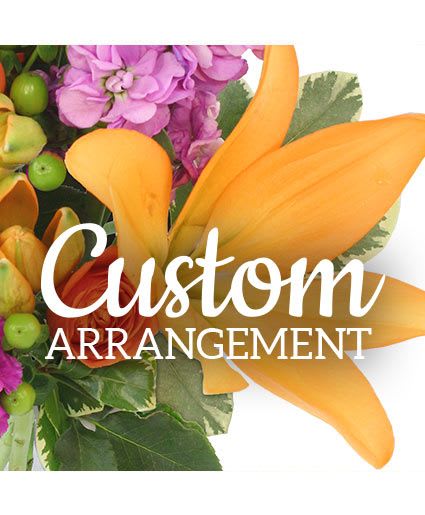 Custom Arrangement Designer's Choice - Bright orange calla lilies take center stage in this designer's choice flower arrangement, making it an energetic "just because" bouquet that feels both modern and heartfelt. The dramatic orange blooms are balanced by lush clusters of purple hydrangea-like flowers and small green berry accents, creating a bold color contrast that reads joyful and contemporary-perfect for birthdays, cheerful thank-yous, or surprising someone who could use a lift.  Dense, textural foliage-including broad variegated and deep green leaves-frames the blooms and adds depth, giving the composition a polished, garden-fresh look. The mix of orange, purple, green, white, and other seasonal tones lets the designer tailor the palette while keeping the calla lilies as the focal point; sizes and specific stems will vary with the designer's choice to ensure freshness and visual impact.  Send this arrangement when you want the recipient to feel genuinely seen and celebrated: it's the kind of bouquet that brightens a desk, entry table, or bedside. Care is simple-keep in fresh water, trim stems every couple of days, and display away from direct sunlight and heat to extend vase life; we'll customize the final selection to emphasize the most beautiful, in-season blooms.