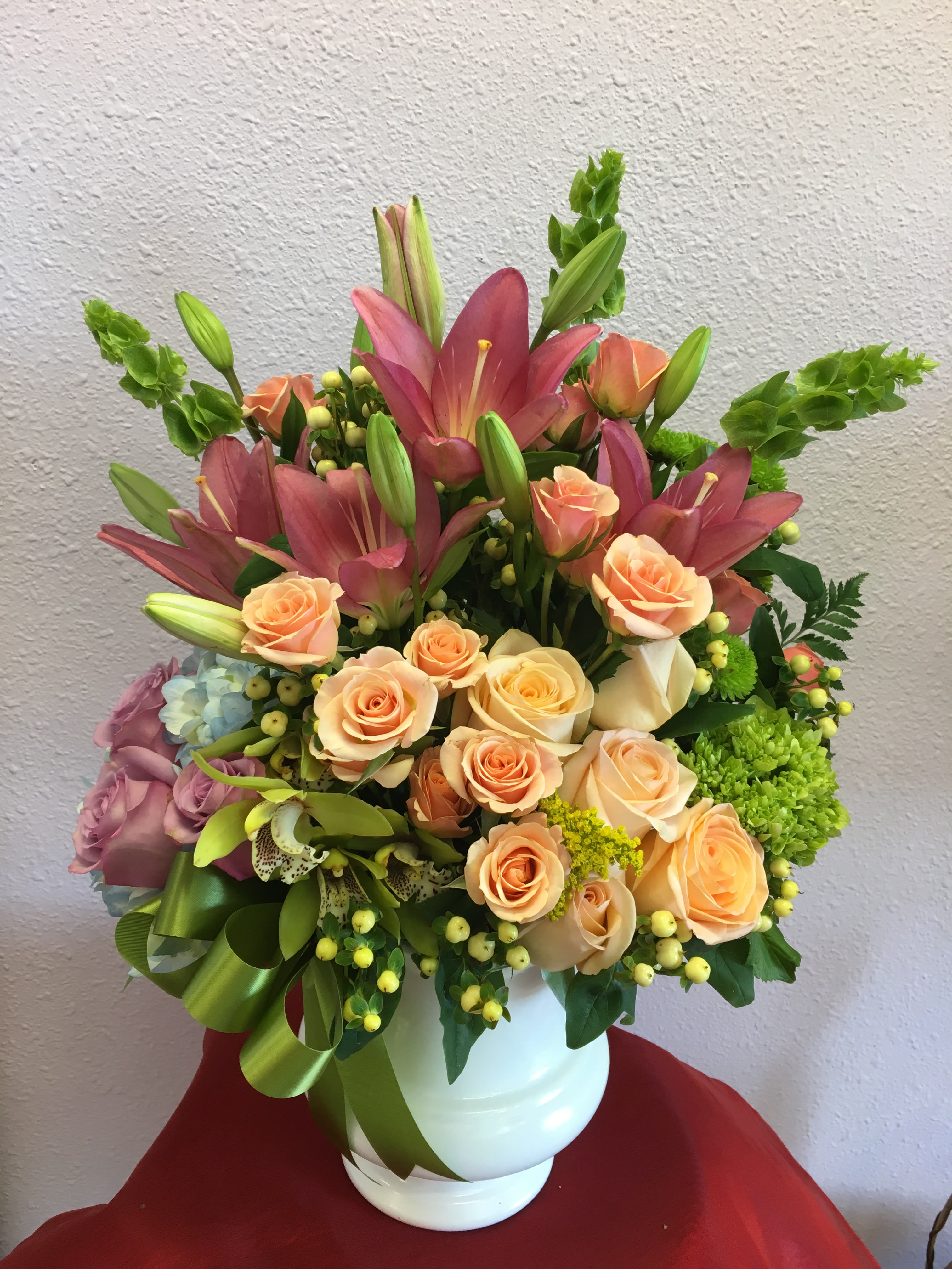 Peaceful Pastels  - Peach roses,peach spray rose  pink lilies, bells of Ireland, green and blue hydrangeas and lavender roses. 