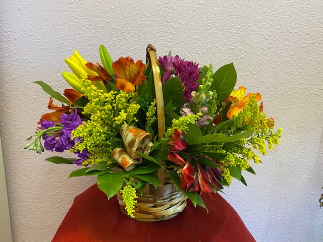Autumn Greetings by Forever Flowers - This beautiful fall colored basket contains yellow lilies, orange Alstroemeria, purple Stock, and matching accents.