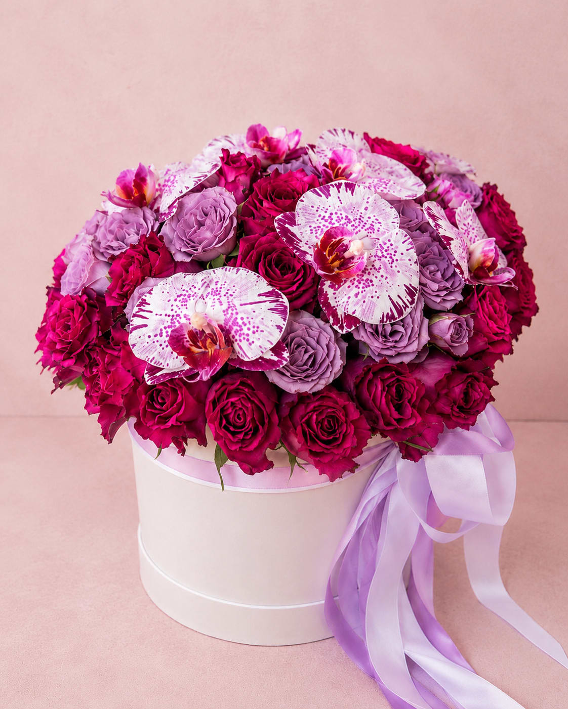 Shakti's Orchid Symphony – Luxury Hat Box - Inspired by Shakti, the Hindu embodiment of divine feminine energy, beauty, and creative power, this luxurious arrangement is a celebration of elegance in full bloom.  Shakti's Orchid Elegance combines premium lavender roses with exquisite Phalaenopsis orchids and carefully selected seasonal blooms, creating a refined composition rich in texture, color, and graceful movement. Soft lavender tones blend effortlessly with vibrant orchid accents, while lush greenery and premium flowers add depth and sophistication.  Designed in a luxurious hat box, this arrangement is perfect for milestone birthdays, anniversaries, Mother's Day, grand celebrations, corporate gifting, or anyone who appreciates extraordinary floral artistry.  Every arrangement is handcrafted by Flower Fairy using the freshest premium flowers available. Seasonal substitutions may occasionally be necessary while preserving the overall style, color palette, luxurious character, and value of the design.  Features: Premium lavender and purple roses Elegant Phalaenopsis orchids Seasonal accent flowers Fresh premium greenery Luxury hat box presentation Handcrafted by Flower Fairy Available in Standard, Deluxe, and Premium sizes Same-day flower delivery throughout the Phoenix Metro Area