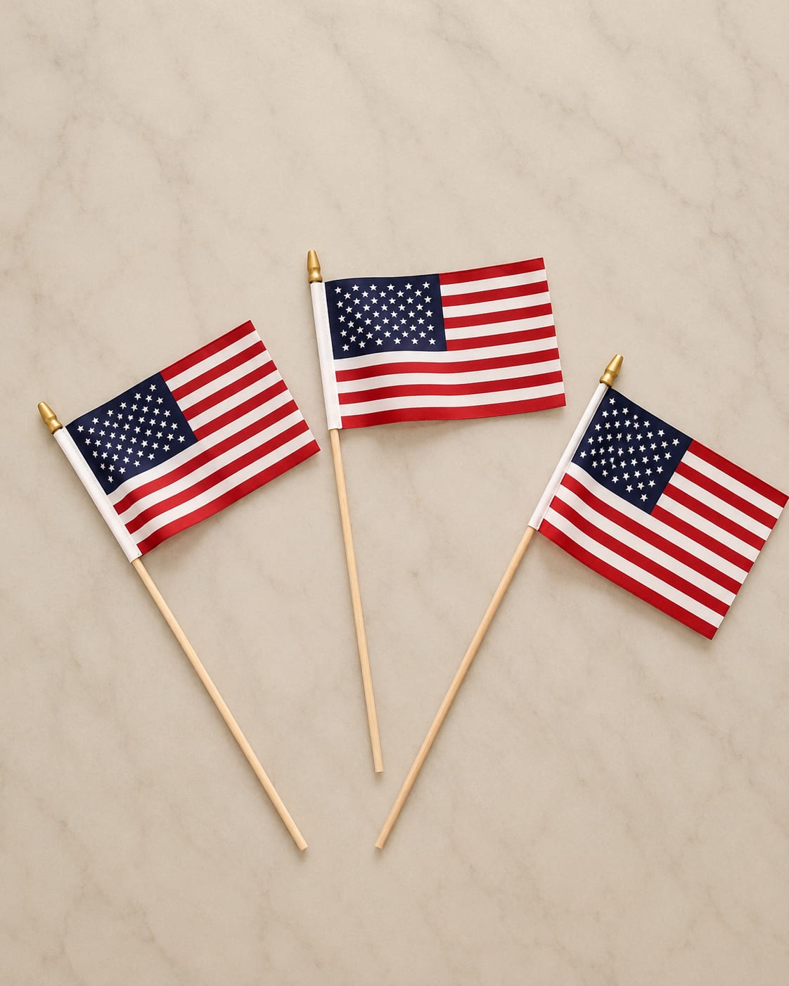  Flags - A single small American flag on a thin wooden stick topped with a gold finial adds a crisp patriotic touch to any flower arrangement or centerpiece. This flag in red, white, and blue has a clear, evenly printed stars-and-stripes pattern that reads well at a glance-perfect for Memorial Day, Fourth of July, Veterans Day, or to honor a service member.  Lightweight and compact, the handheld flag slips easily between stems or into floral foam without overpowering the flowers; its neutral-scale presence keeps attention on the arrangement while making the sentiment unmistakable. Arrives ready to place-just insert gently and avoid bending the wooden stick during handling.