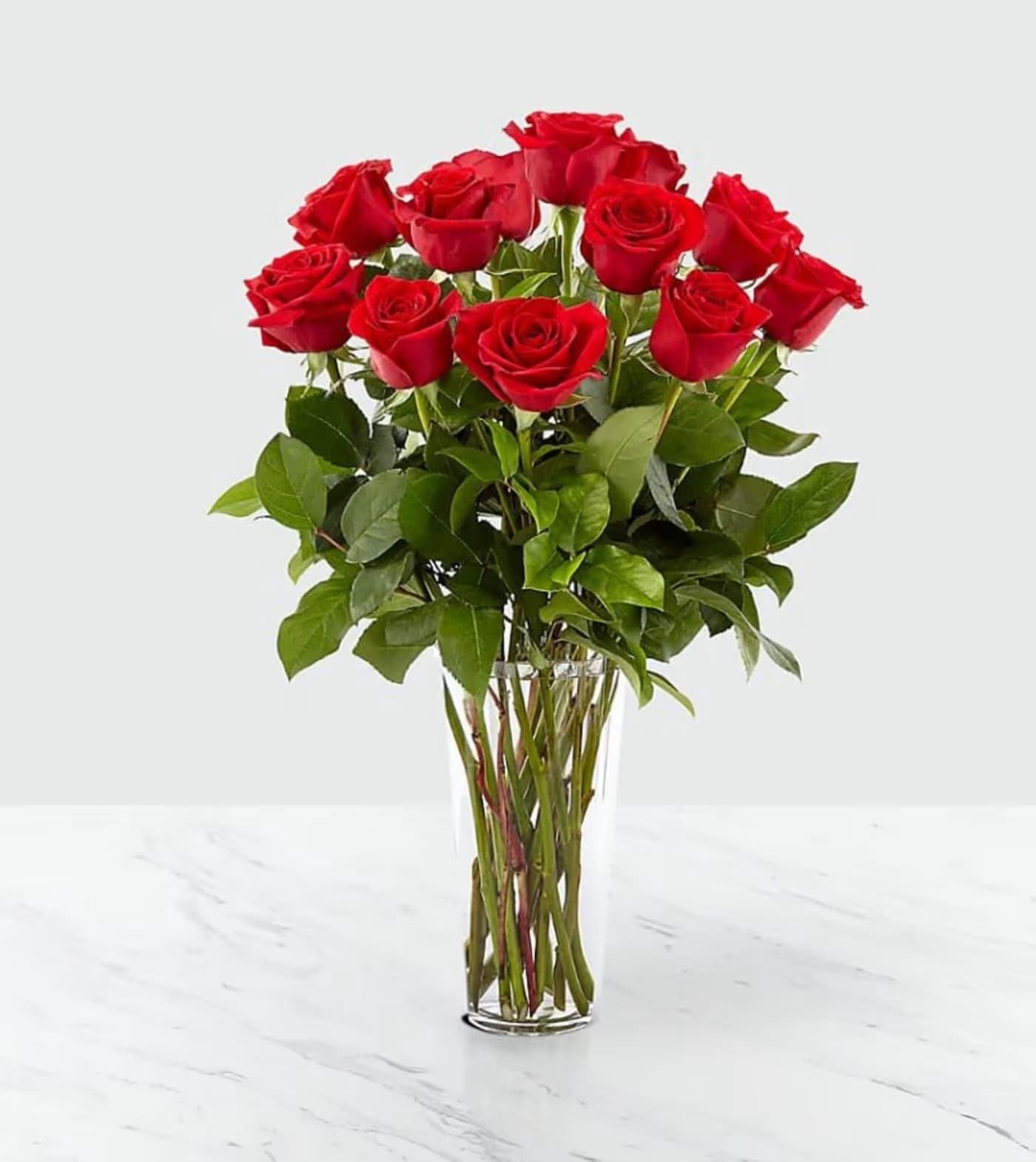 Red roses arranged in a clear glass vase